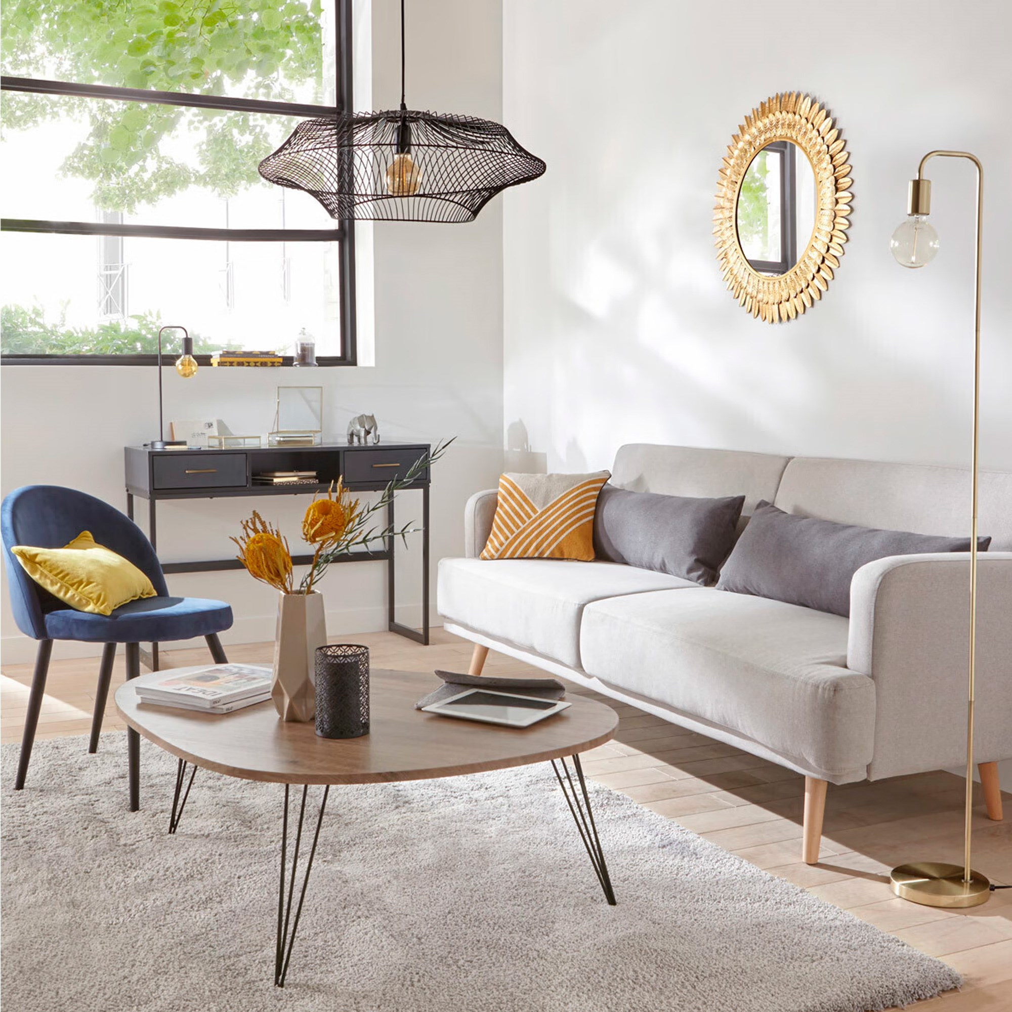 Salón moderno con sofá, mesa de centro, silla, lámpara y espejo. Paredes blancas y ventana grande.