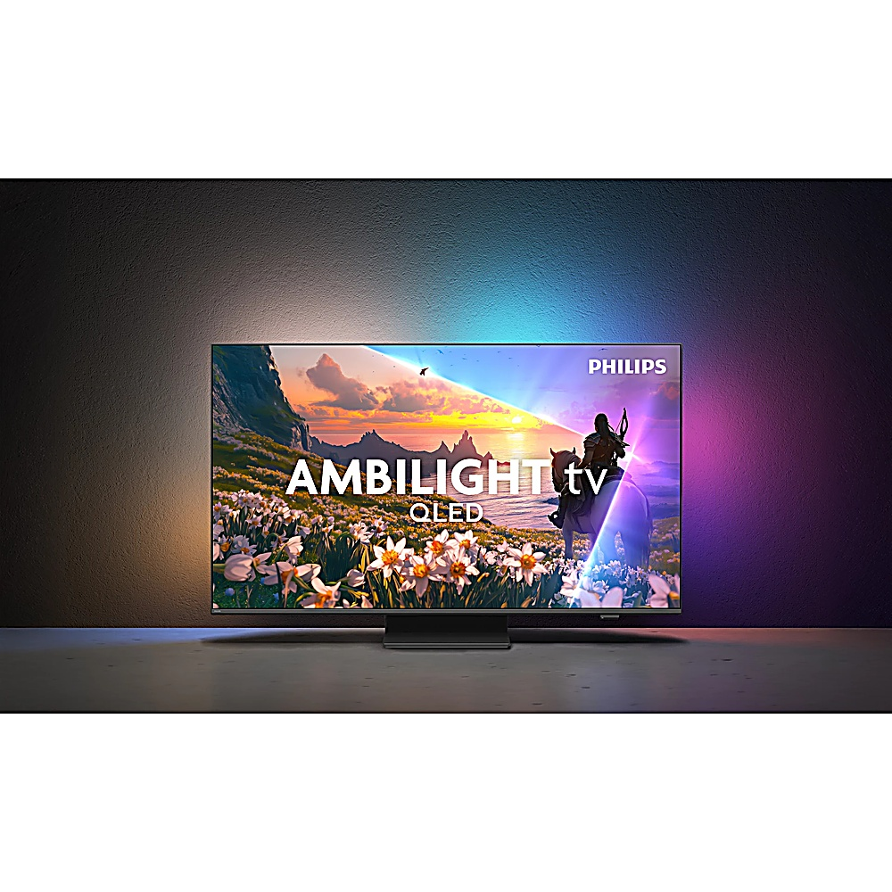 Telewizor Philips Ambilight QLED wyświetla obraz osoby jadącej konno. Telewizor stoi na stojaku, a tło jest ciemne z kolorowymi światłami.