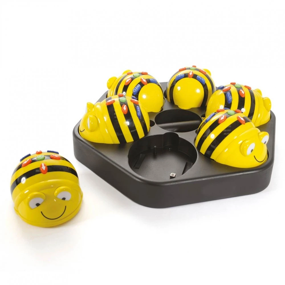Abejas de juguete amarillas con rayas negras en una bandeja negra. Una abeja está separada. Todas tienen caras sonrientes y botones coloridos.