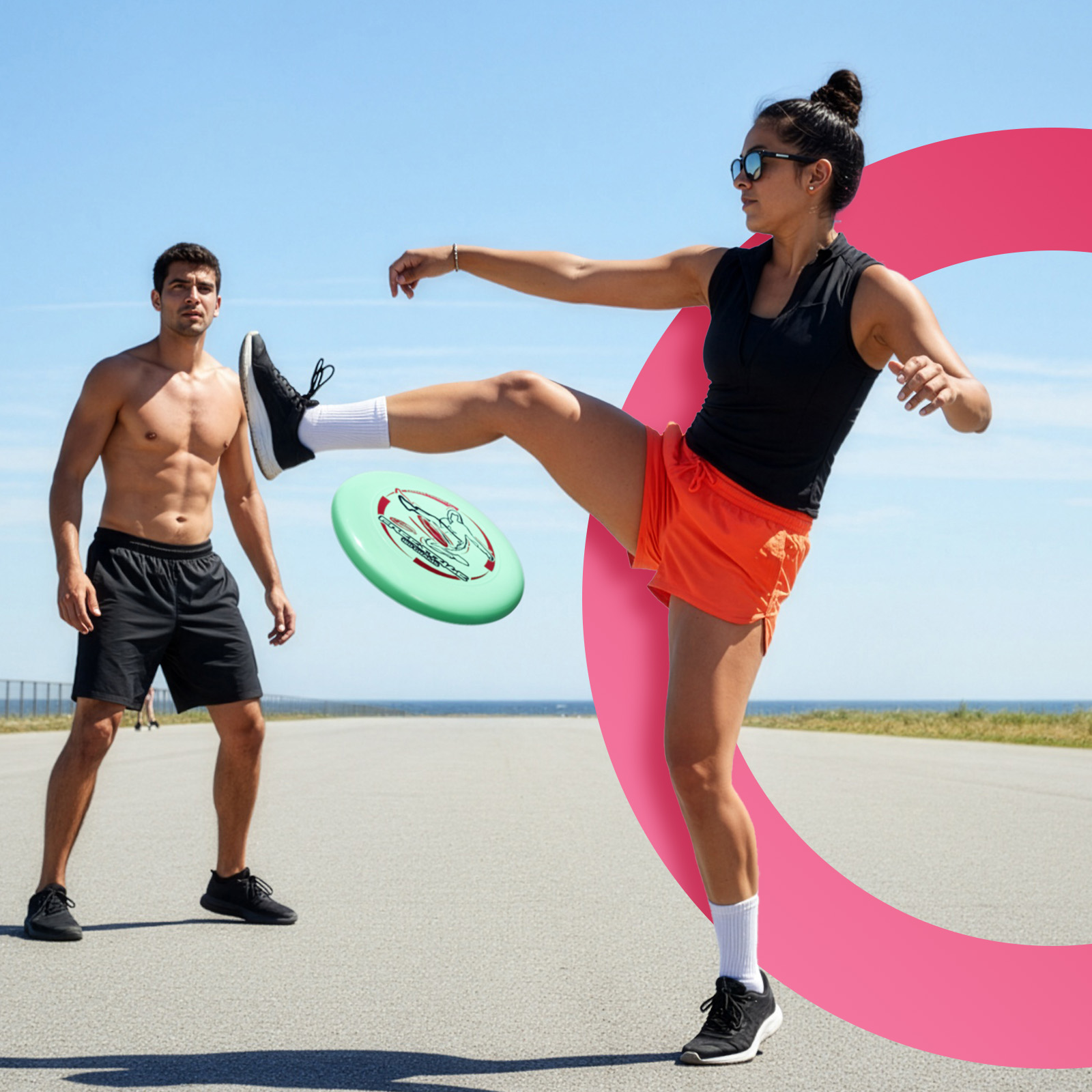 Eine Frau tritt eine Frisbeescheibe in Richtung eines Mannes. Sie trägt eine Sonnenbrille, ein schwarzes Oberteil, orangefarbene Shorts. Der Mann ist oben ohne.