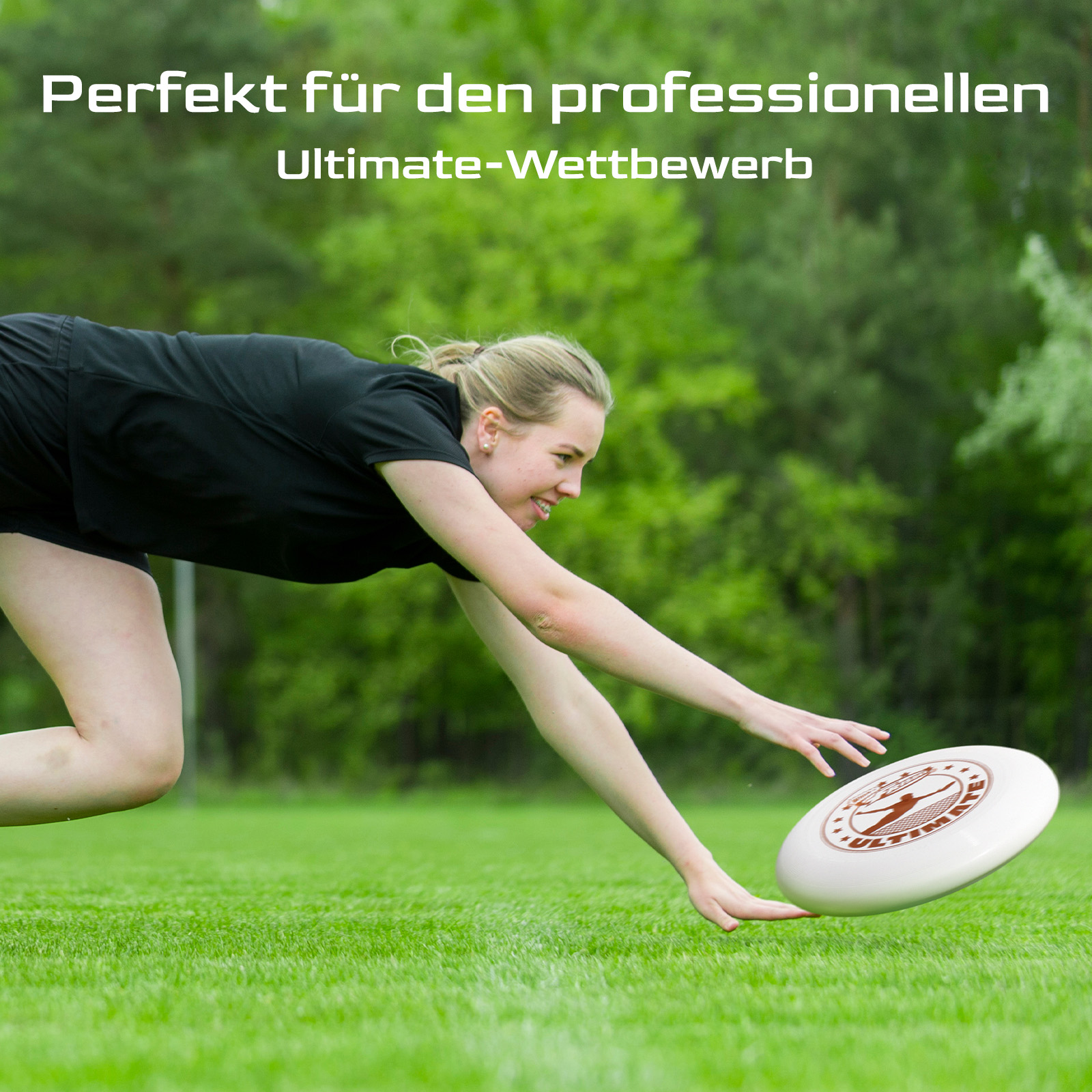 Eine Frau taucht, um eine Frisbee auf einem grünen Feld zu fangen. Der Hintergrund sind verschwommene Bäume.