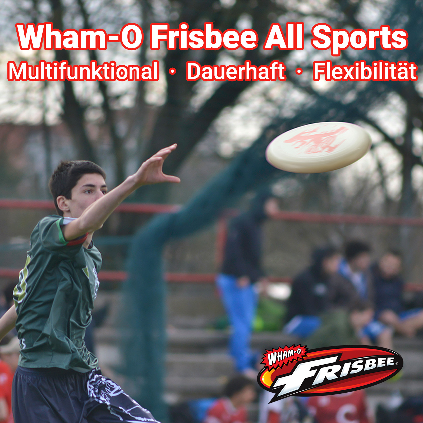 Ein junger Mann wirft eine weiße Frisbee mit rotem Design. Er trägt ein grünes Hemd. Andere sind im Hintergrund.