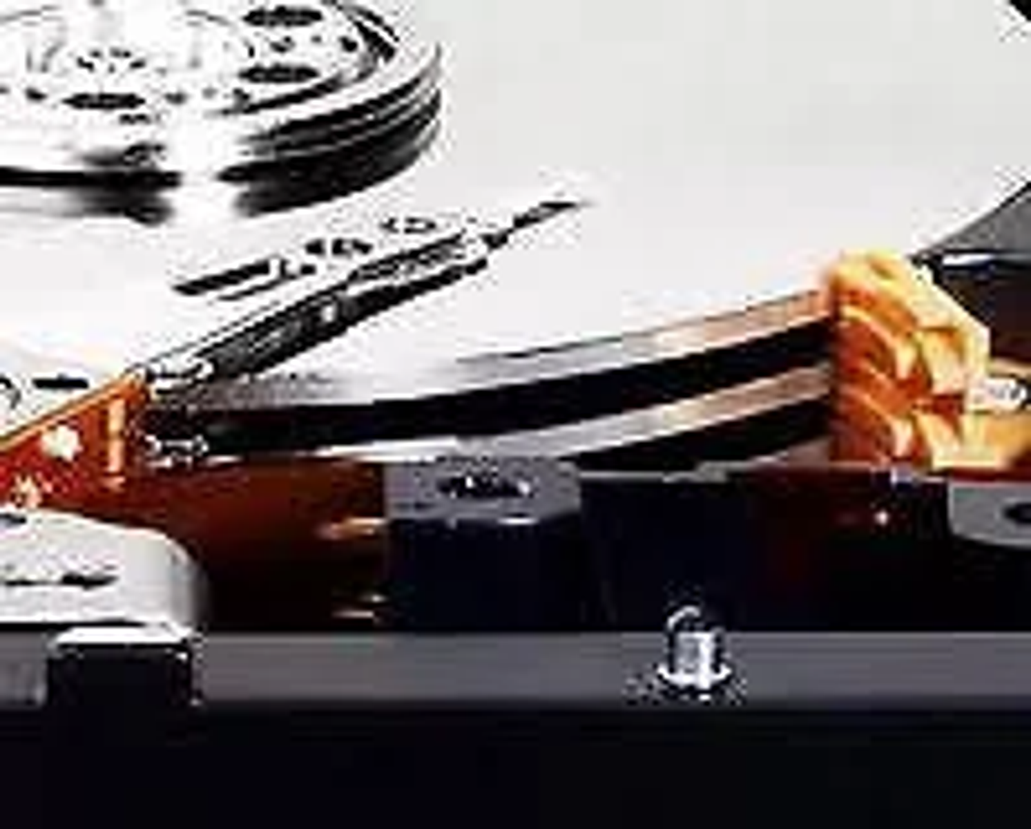 Zbliżenie wnętrza dysku twardego pokazujące talerze, głowice odczytu/zapisu i elementy pamięci masowej. Widoczne są kolory metaliczne i pomarańczowe.