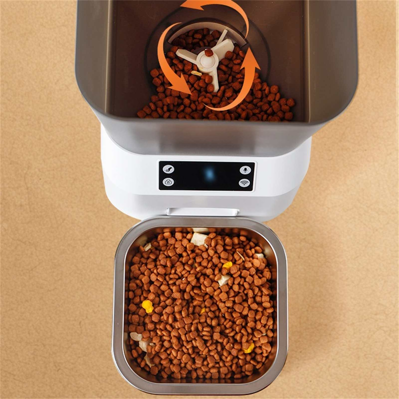 Ein automatischer Futterautomat mit Futter. Der obere Behälter zeigt die Ausgabe von Futter. Der untere Behälter ist voll.