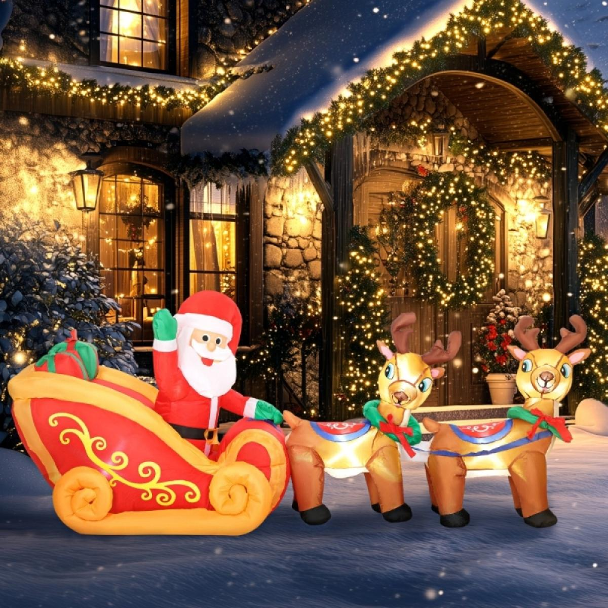 Ein aufblasbarer Weihnachtsmann winkt von einem Schlitten, der von zwei Rentieren gezogen wird. Im Hintergrund ein Haus mit Lichtern. Schnee fällt.