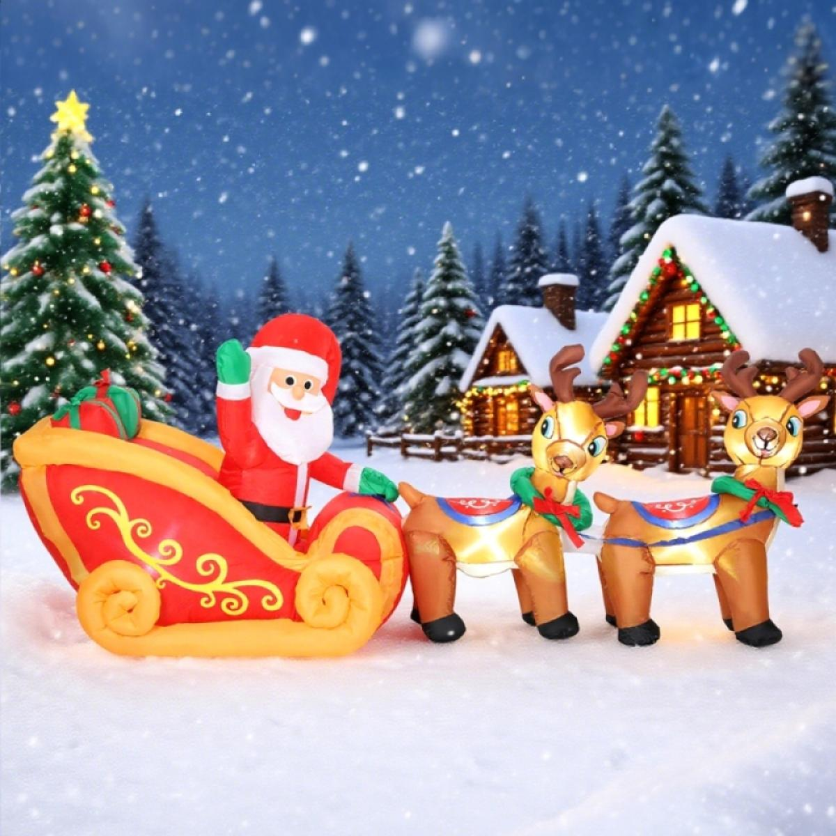 Aufblasbarer Weihnachtsmann in einem Schlitten, gezogen von zwei Rentieren, in einer Schneelandschaft mit Haus und Weihnachtsbäumen.