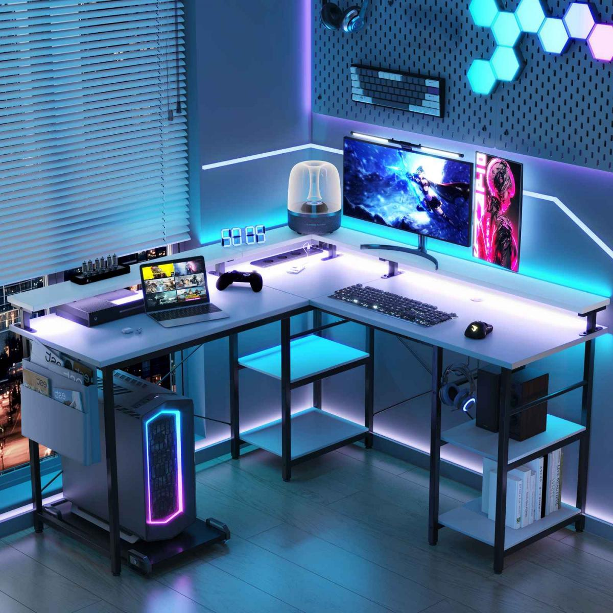 Ein Gaming-Setup mit weißem Schreibtisch, mehreren Monitoren und einem Computer. Der Raum ist mit blauen und lila LED-Leuchten beleuchtet.