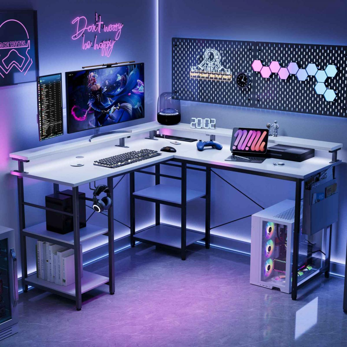 Gaming-Setup mit weißem Schreibtisch, Monitoren, Tastatur und Computer. Neonlichter und Dekoration schaffen eine moderne, technikorientierte Umgebung.