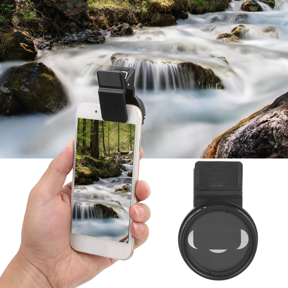 Eine Hand hält ein Telefon mit Objektiv, das eine Wasserfallszene zeigt. Im Hintergrund ein verschwommener Wasserfall und Felsen. Eine separate Linse wird ebenfalls gezeigt.