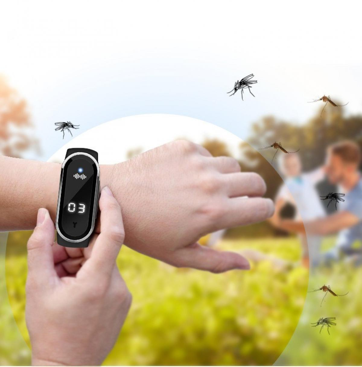Eine Person trägt eine schwarze Smartwatch am Handgelenk, Mücken fliegen herum. Im Hintergrund sind verschwommene Personen.