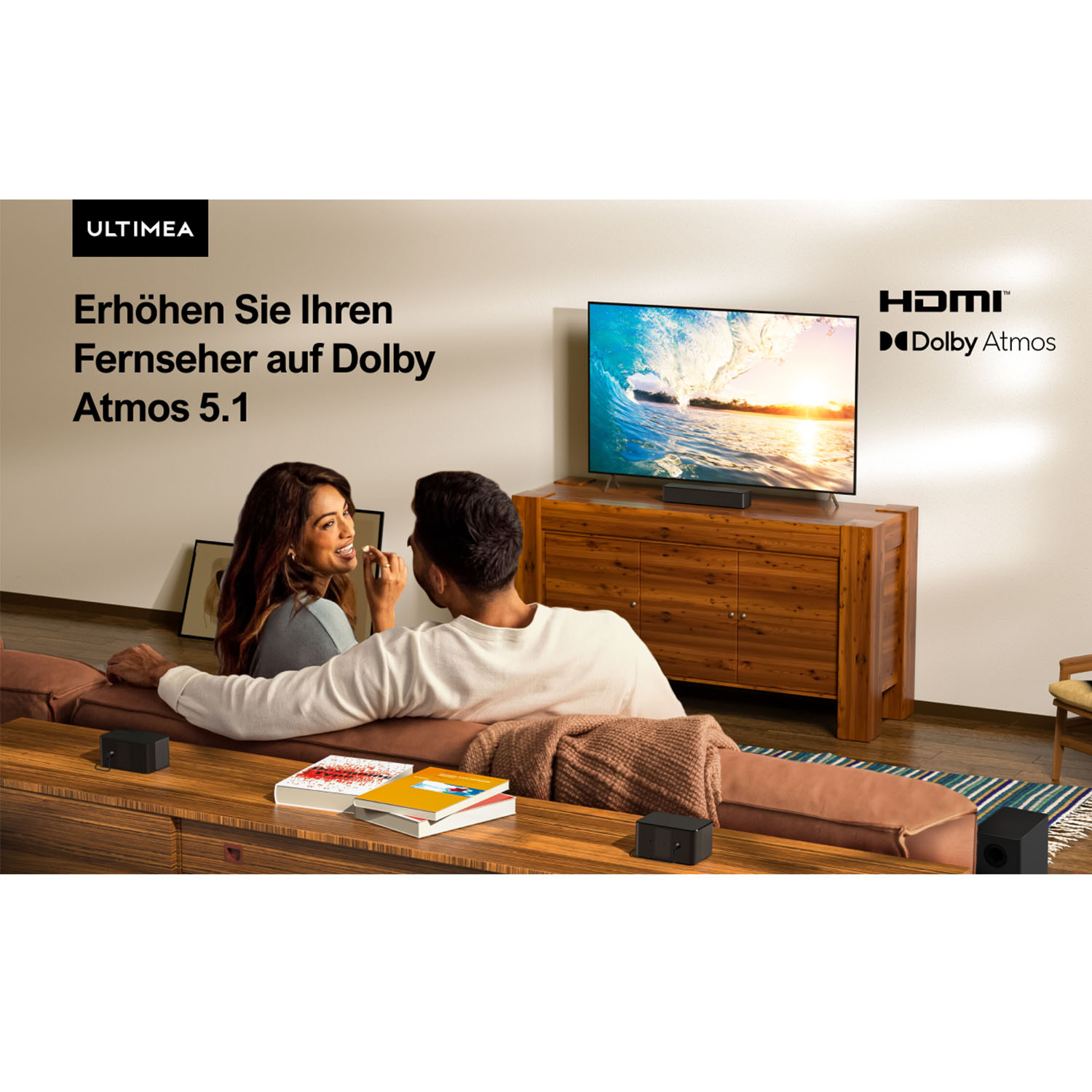 Para siedzi na kanapie oglądając telewizor z obrazem fali. Głośniki, książki i koc znajdują się na drewnianym stole.