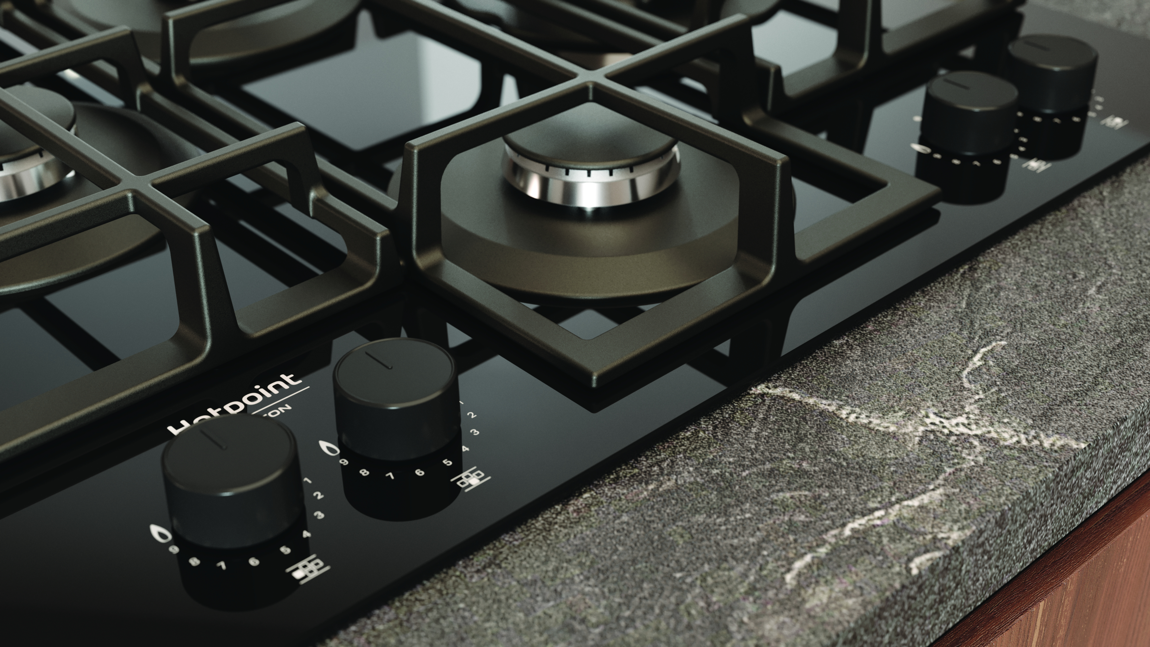 Primo piano di un fornello a gas nero con accenti argentati. Manopole e bruciatori visibili, su un piano di lavoro scuro.