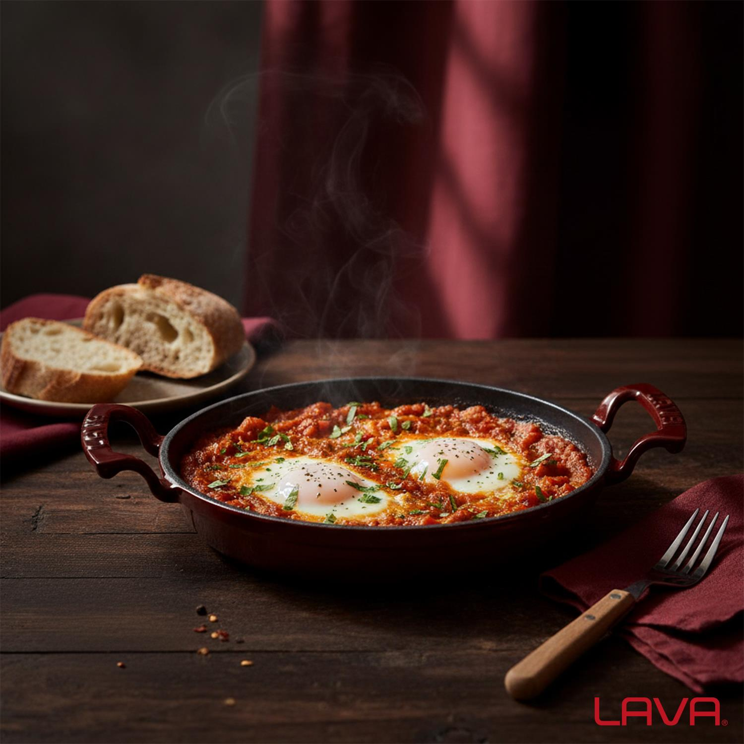 İki yumurtalı bir shakshuka tavası, bir tabakta ekmek, bir çatal ve ahşap bir masada kırmızı bir peçete. Buhar yükseliyor.