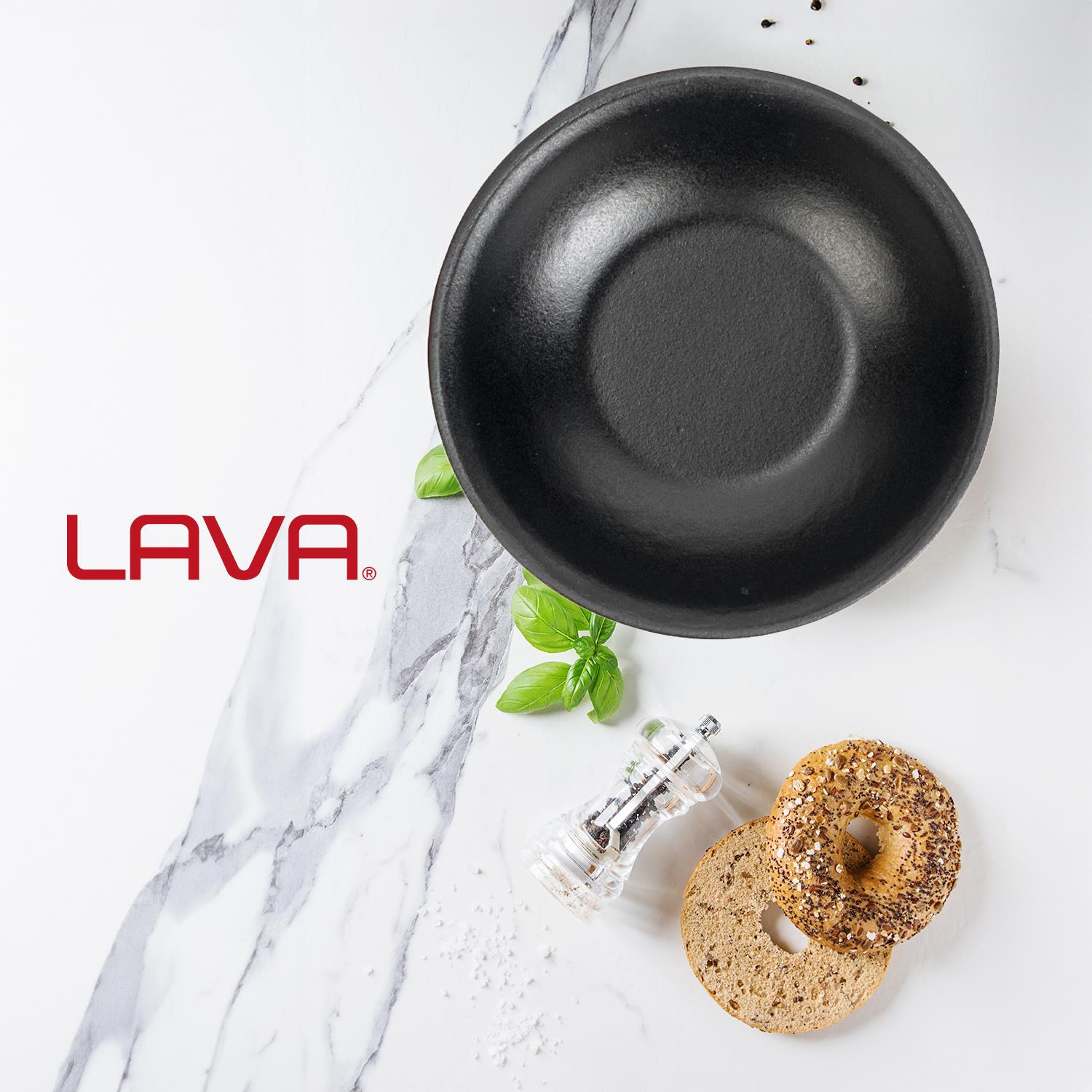 Siyah bir kase, simit, biber değirmeni ve mermer bir yüzeyde fesleğen. Lava logosu görünür. Baharatlar dağılmış.
