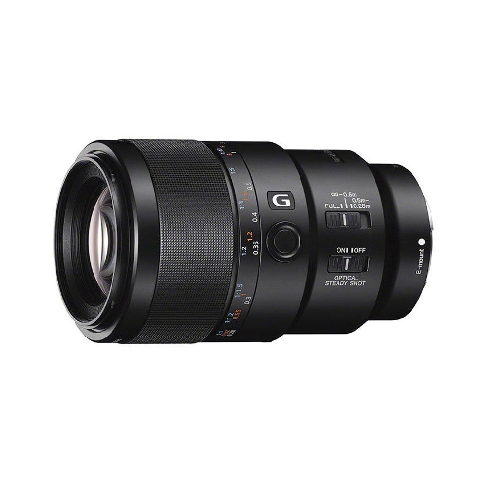 Czarny obiektyw aparatu, z ustawieniami ostrości i innymi oznaczeniami z boku, na białym tle.