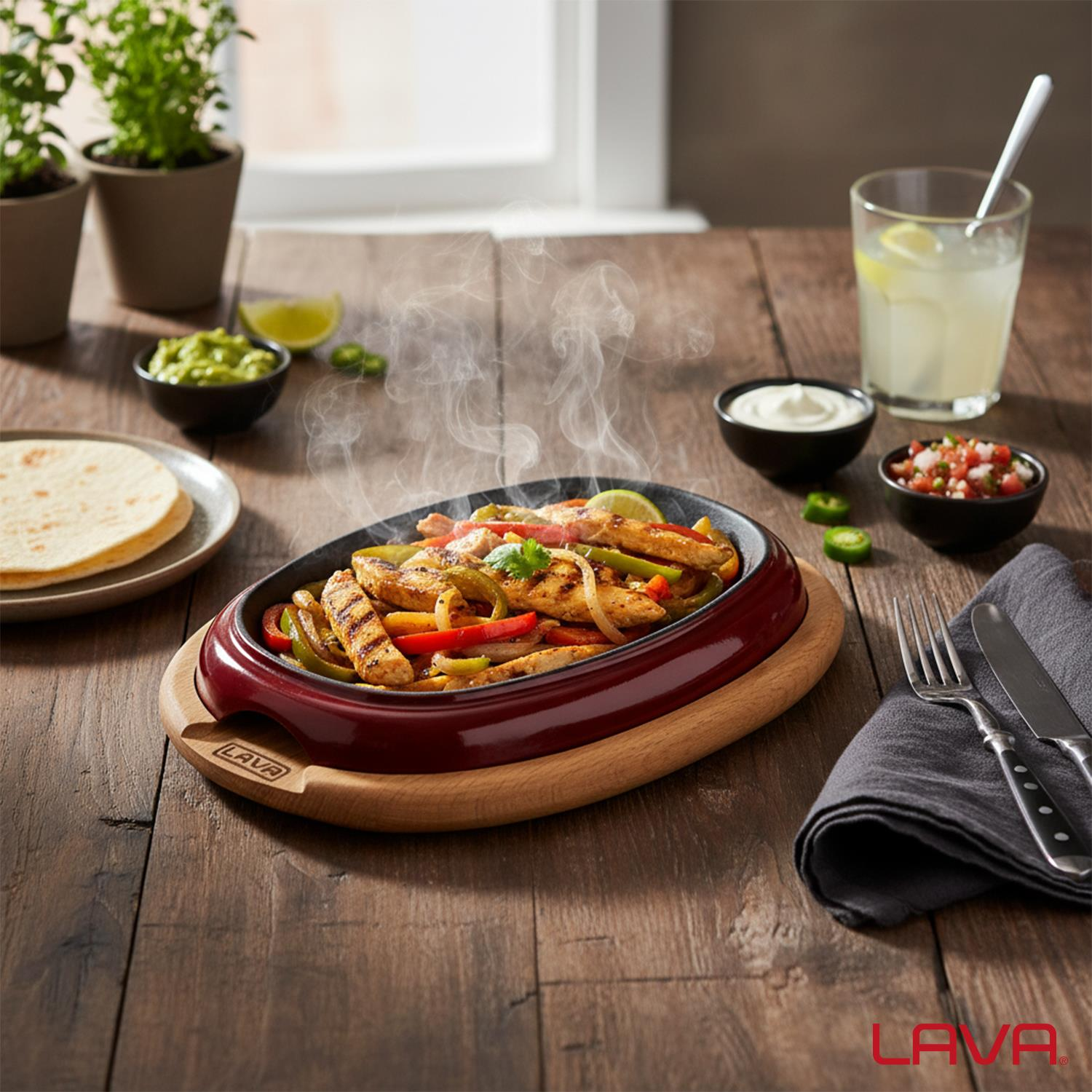 Izgara tavuk, biber ve soğanlı, cızırdayan fajitalar. Tahta bir masa üzerinde tortilla, guacamole ve salsa ile servis edilir.