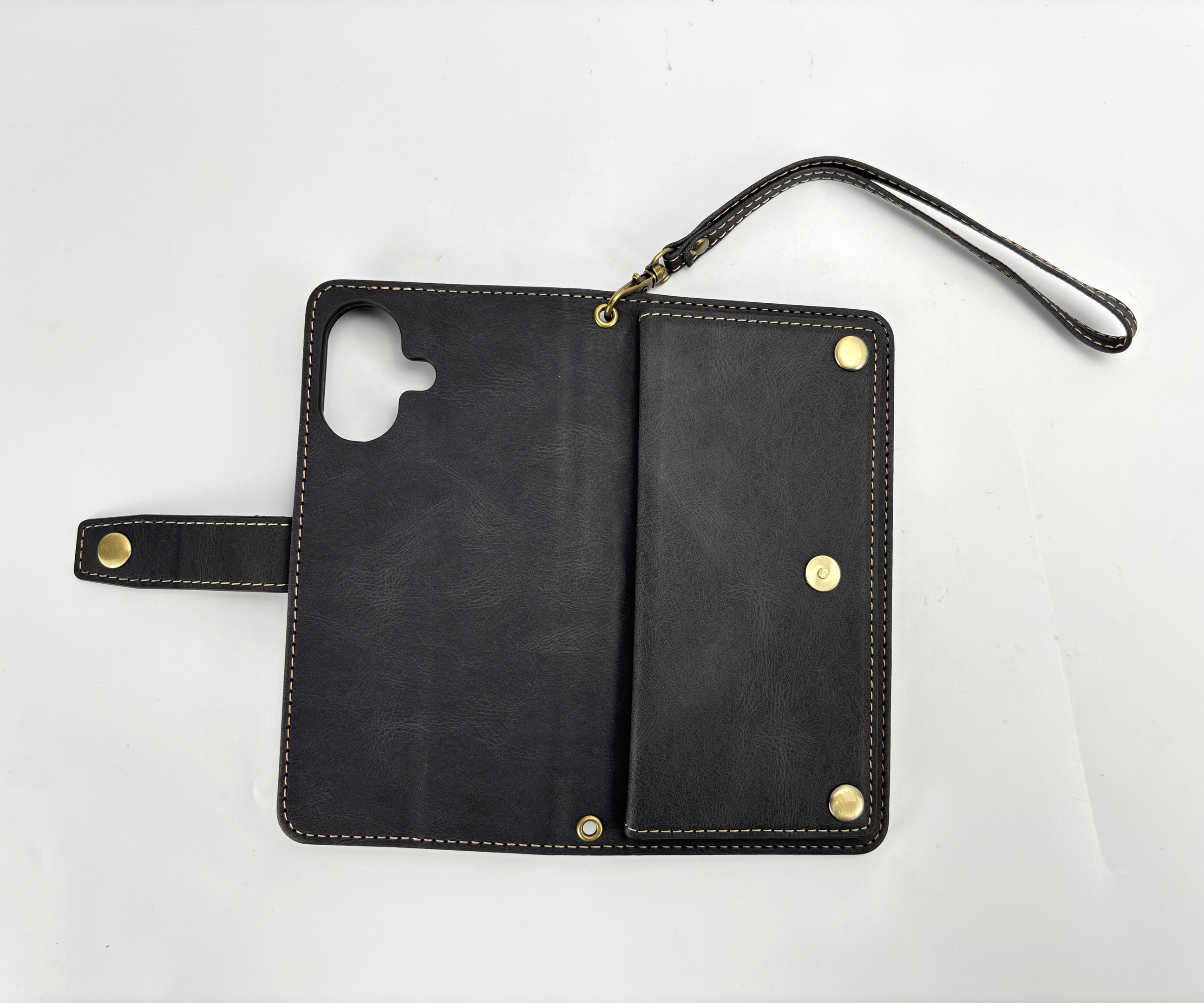Custodia per telefono in pelle nera con finiture dorate. Dotata di cinturino da polso e cuciture bianche.