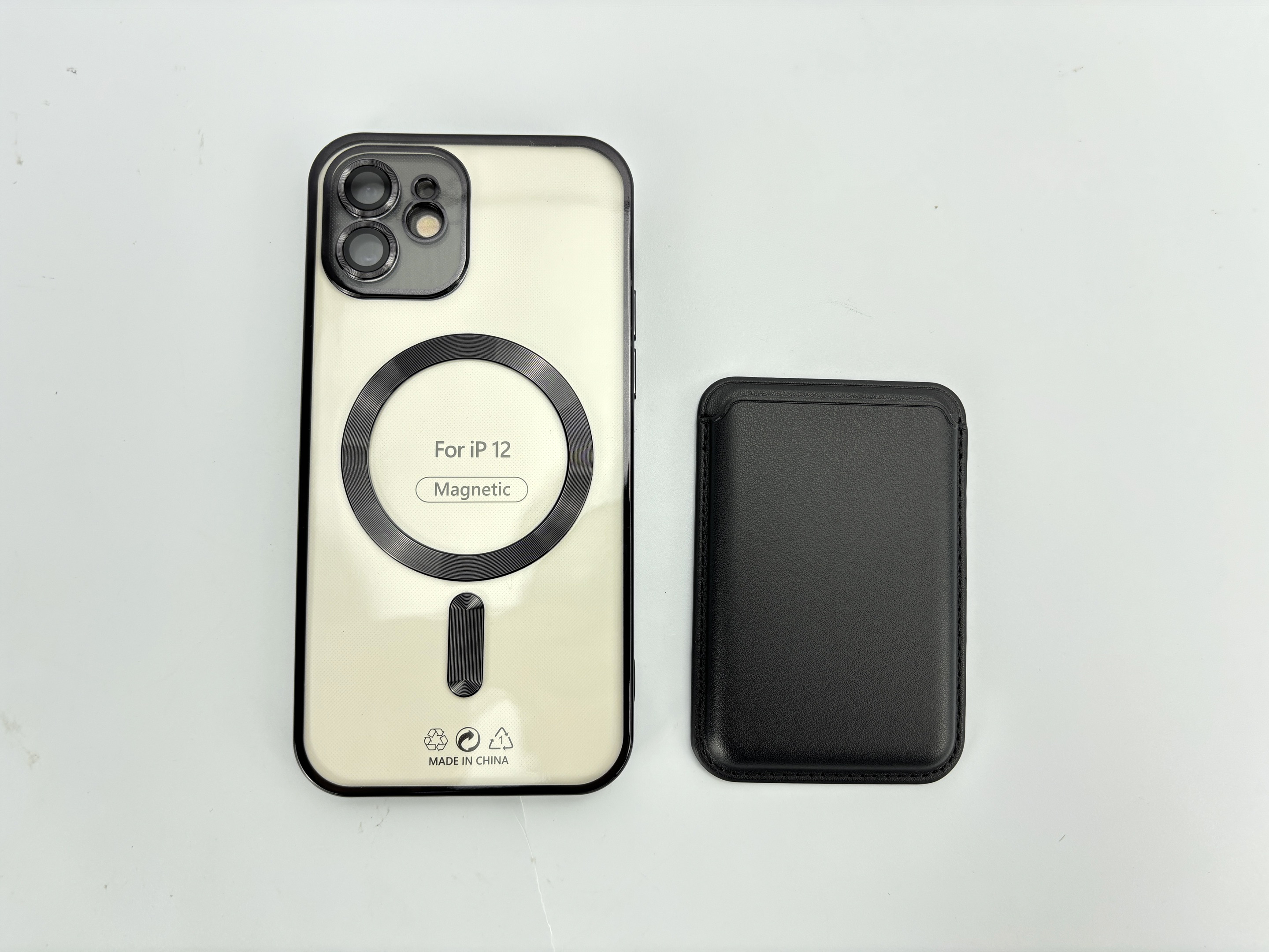 Una custodia per iPhone 12 e un porta carte nero sono su una superficie bianca. La custodia dice 'Magnetic'.