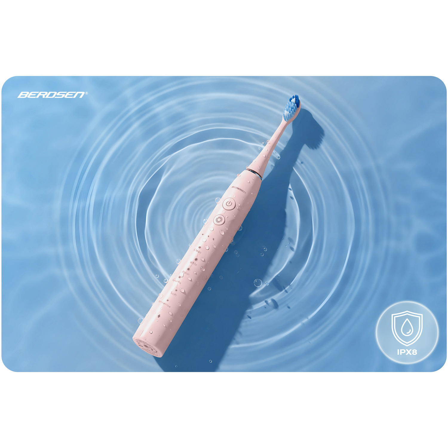Różowa elektryczna szczoteczka do zębów z niebieskim włosiem leży na niebieskiej powierzchni z zmarszczkami wody, widoczna jest nazwa marki.