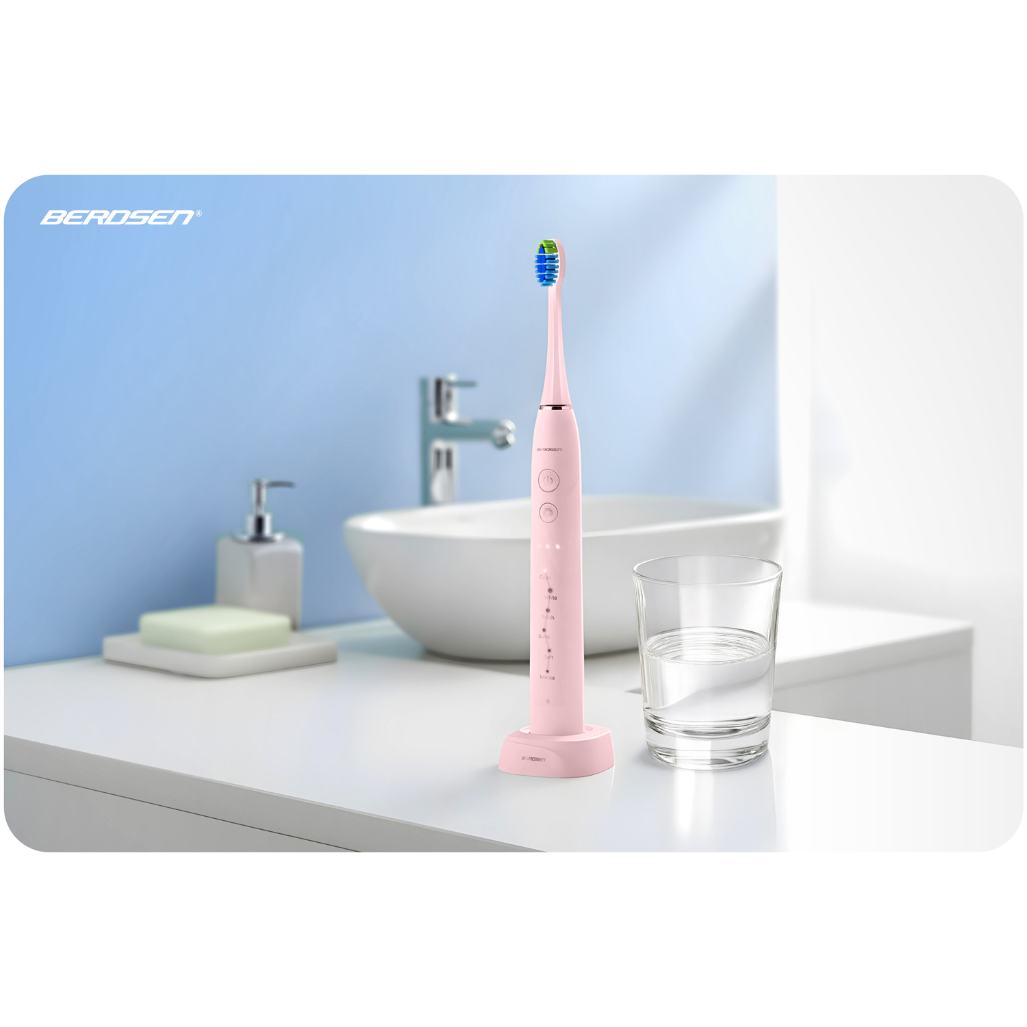 Różowa elektryczna szczoteczka do zębów, stojąca na swojej stacji ładującej, obok szklanki wody. Ustawienie łazienki z niebieską ścianą w tle.
