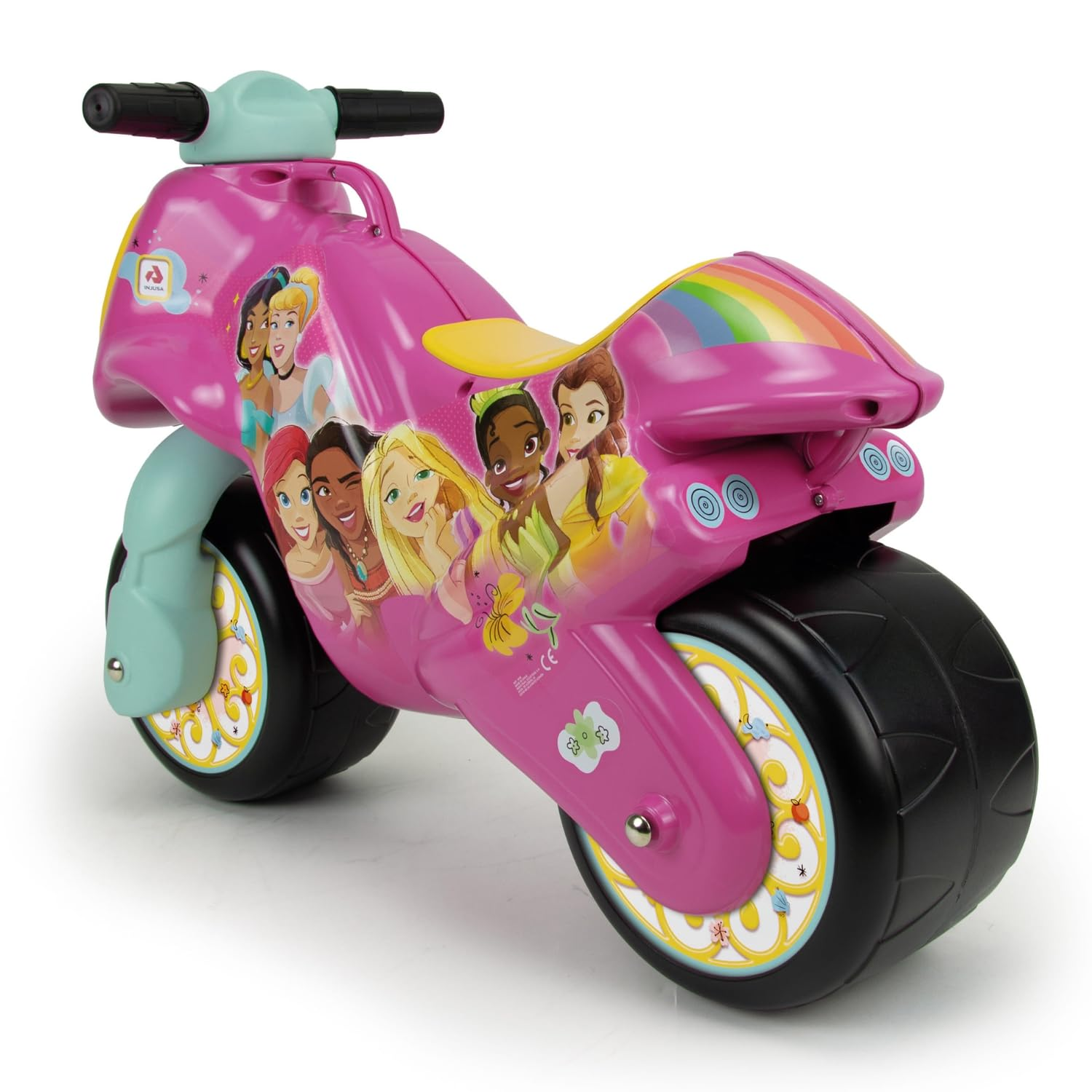 Una motocicleta de juguete rosa con gráficos de princesas. Tiene un diseño de arcoíris, neumáticos negros y asiento amarillo. El fondo es blanco.
