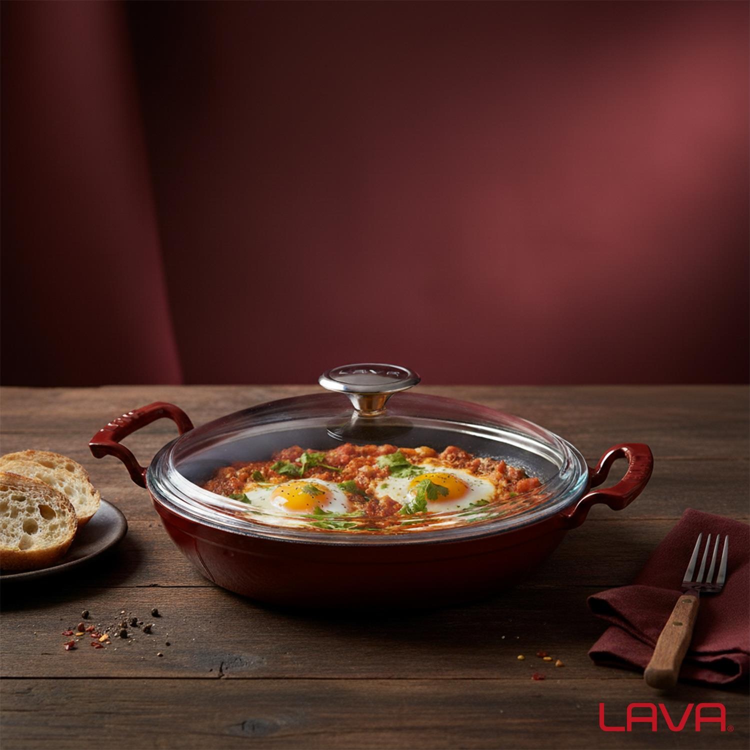 Ahşap bir masada iki yumurta, ekmek, çatal ve peçete ile bir shakshuka tavası. Kırmızı arka plan.