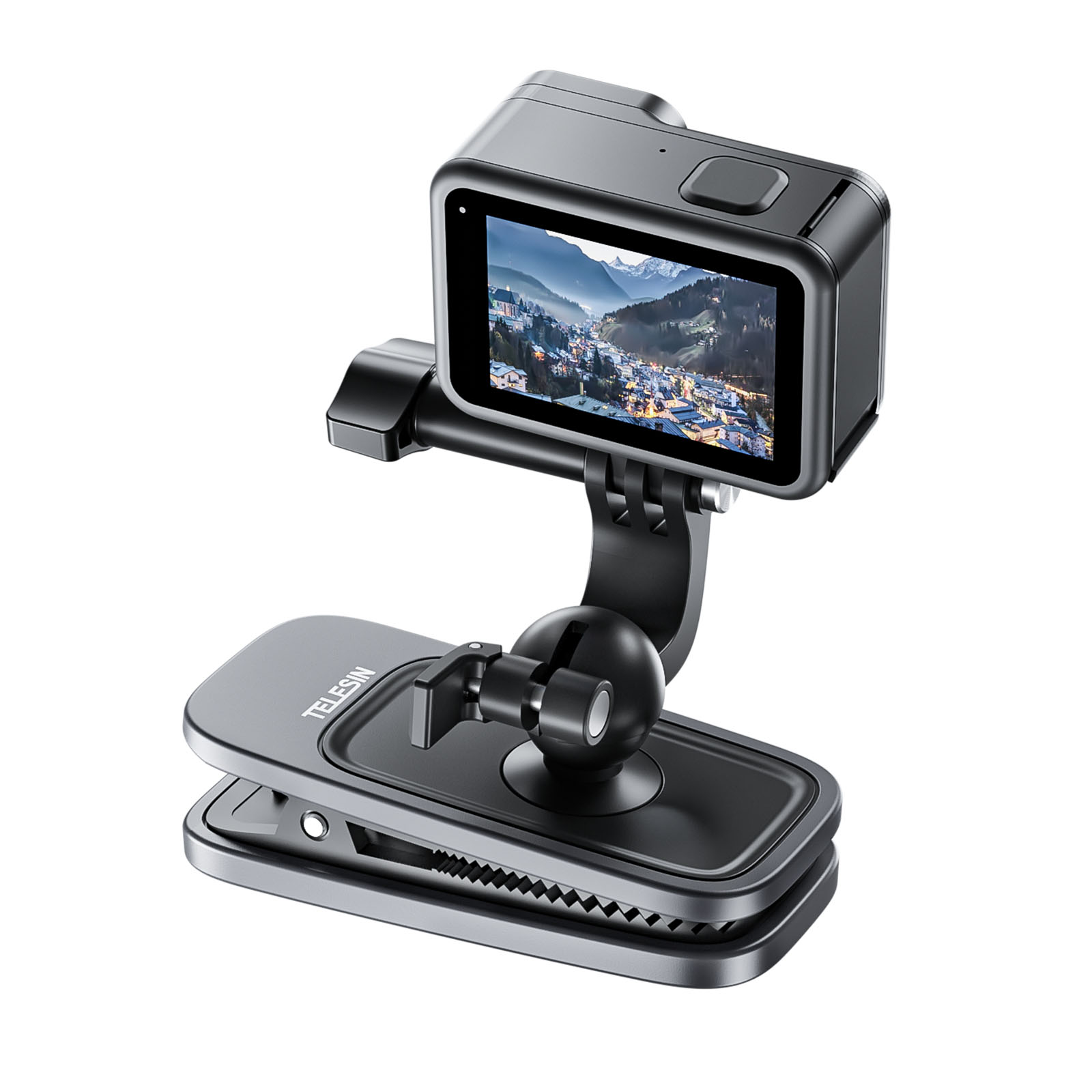 Black action camera on a clip mount. The camera displays a scenic mountain town view.