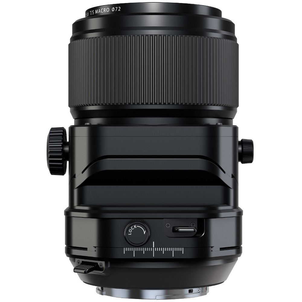 A black camera lens, cylindrical with ribbed sections. It has adjustment dials and markings. The lens is isolated on a white background.