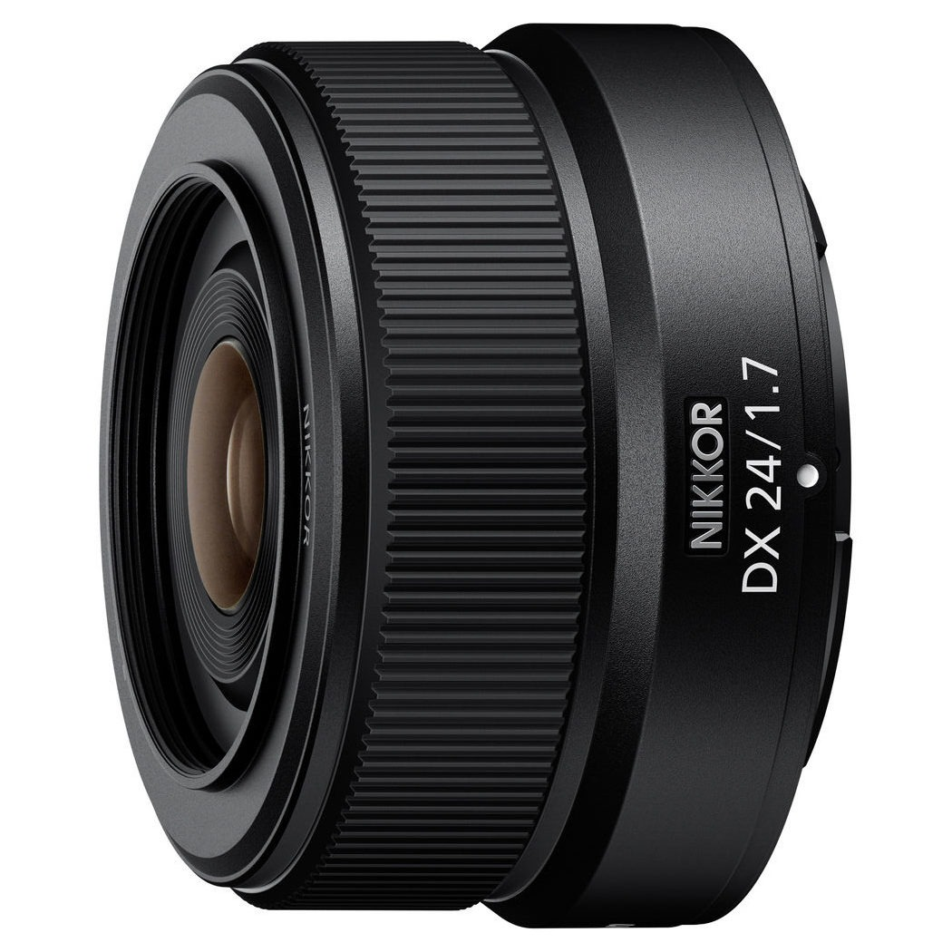 Primer plano de una lente de cámara negra con el texto 'NIKKOR DX 24/1.7' en el lateral. La lente tiene un diseño detallado.