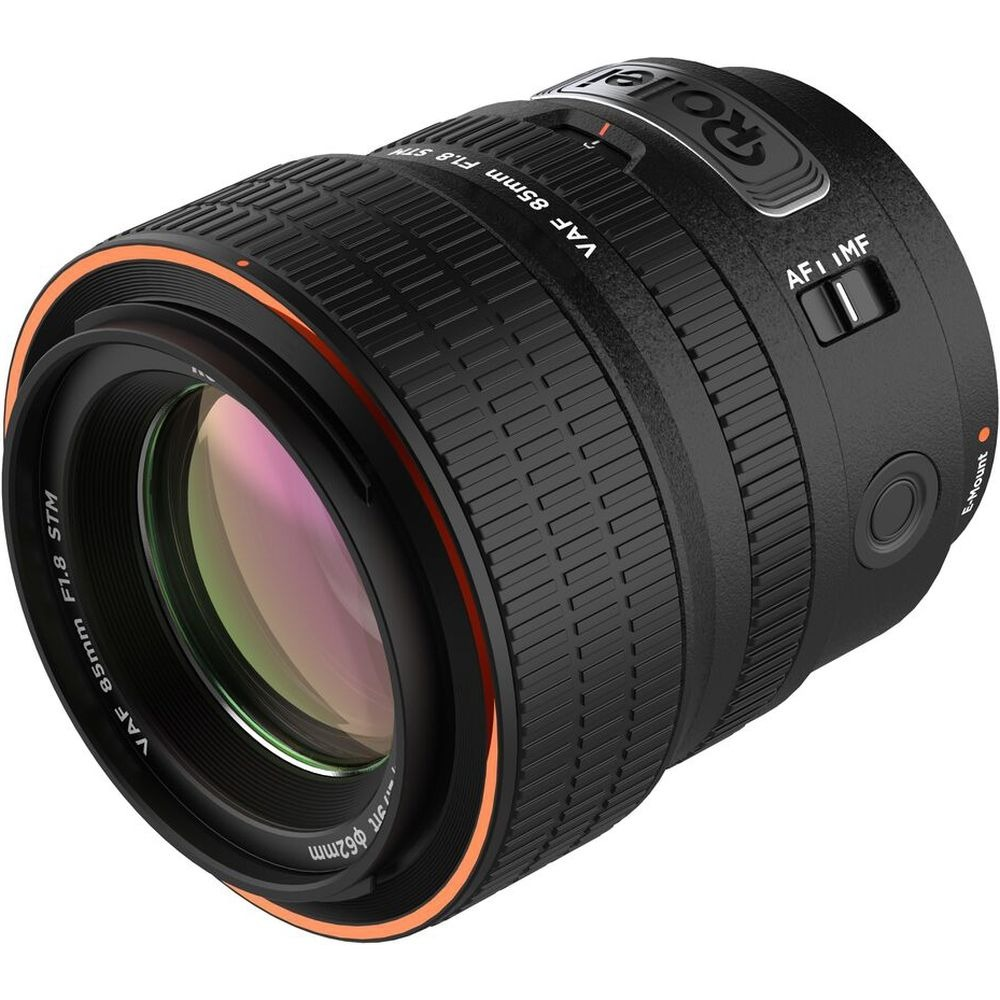 Een Rollei cameralens. Het is zwart met oranje accenten en heeft tekst zoals 'VAF 85mm F1.8 STM' en 'AFI IMF'.