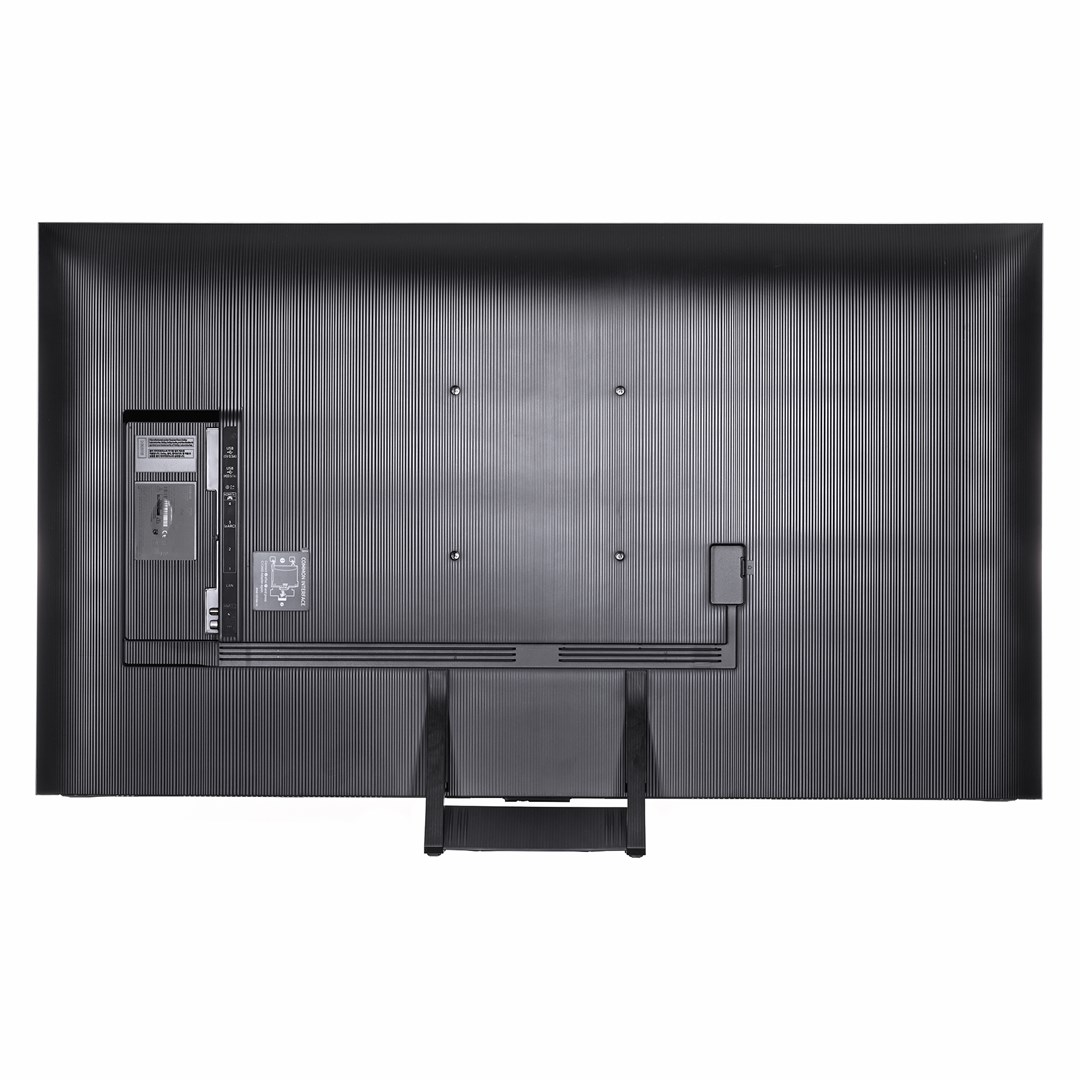 Back of a black Samsung TV. It has a ridged texture, ports, and a stand. Cables are connected, and it sits against a white backdrop.