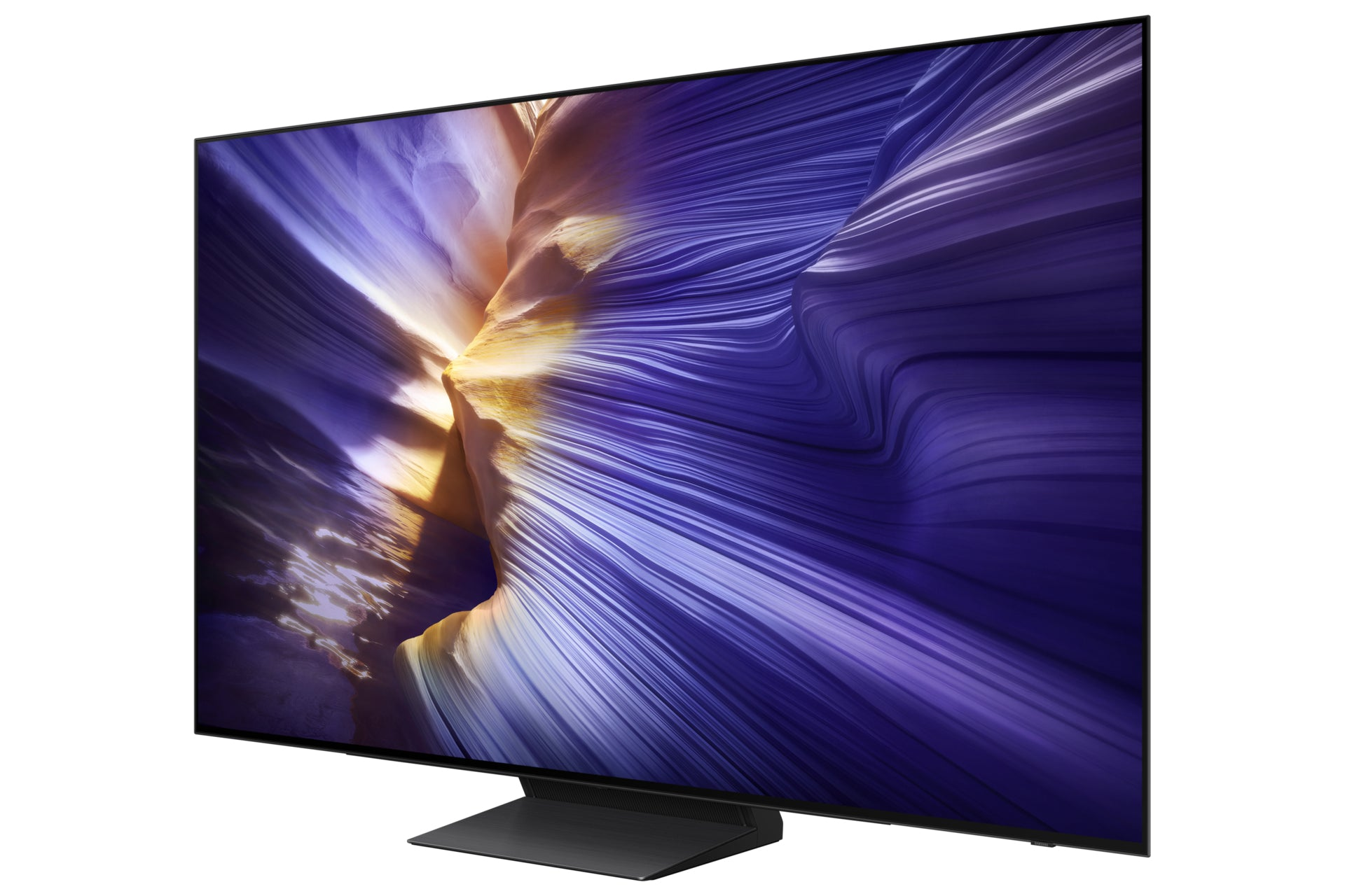 A large TV displays a swirling purple and yellow canyon landscape. The TV is black and sits on a black stand.