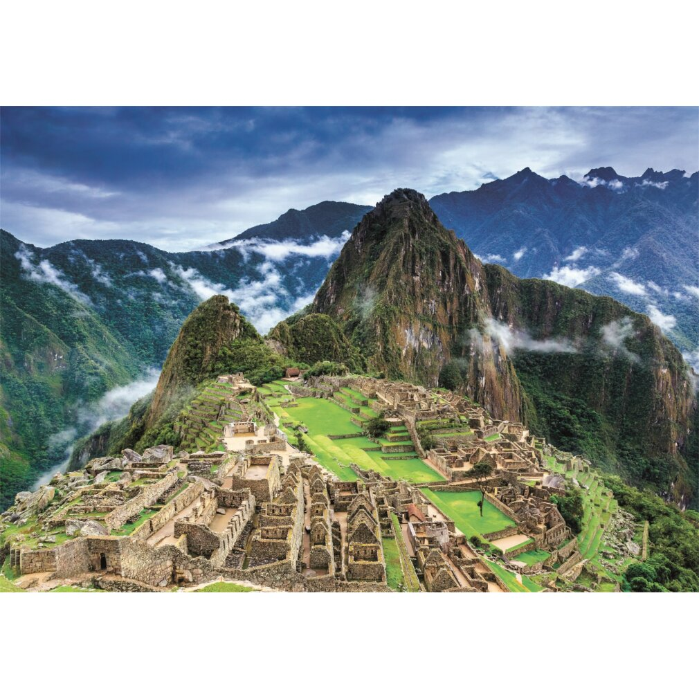 Ciudad montañosa de Machu Picchu. Edificios de piedra en una ladera verde. Montañas y nubes al fondo bajo un cielo azul.