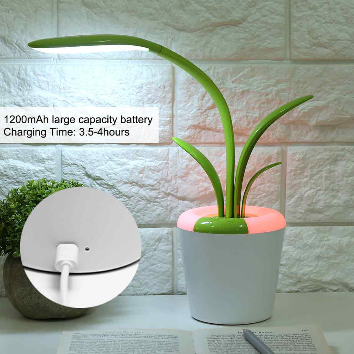 Eine grüne Schreibtischlampe im Blumentopf-Design. Die Lampe hat einen flexiblen Hals und ein helles Licht. Der Topf hat grüne Blätter und ist weiß.