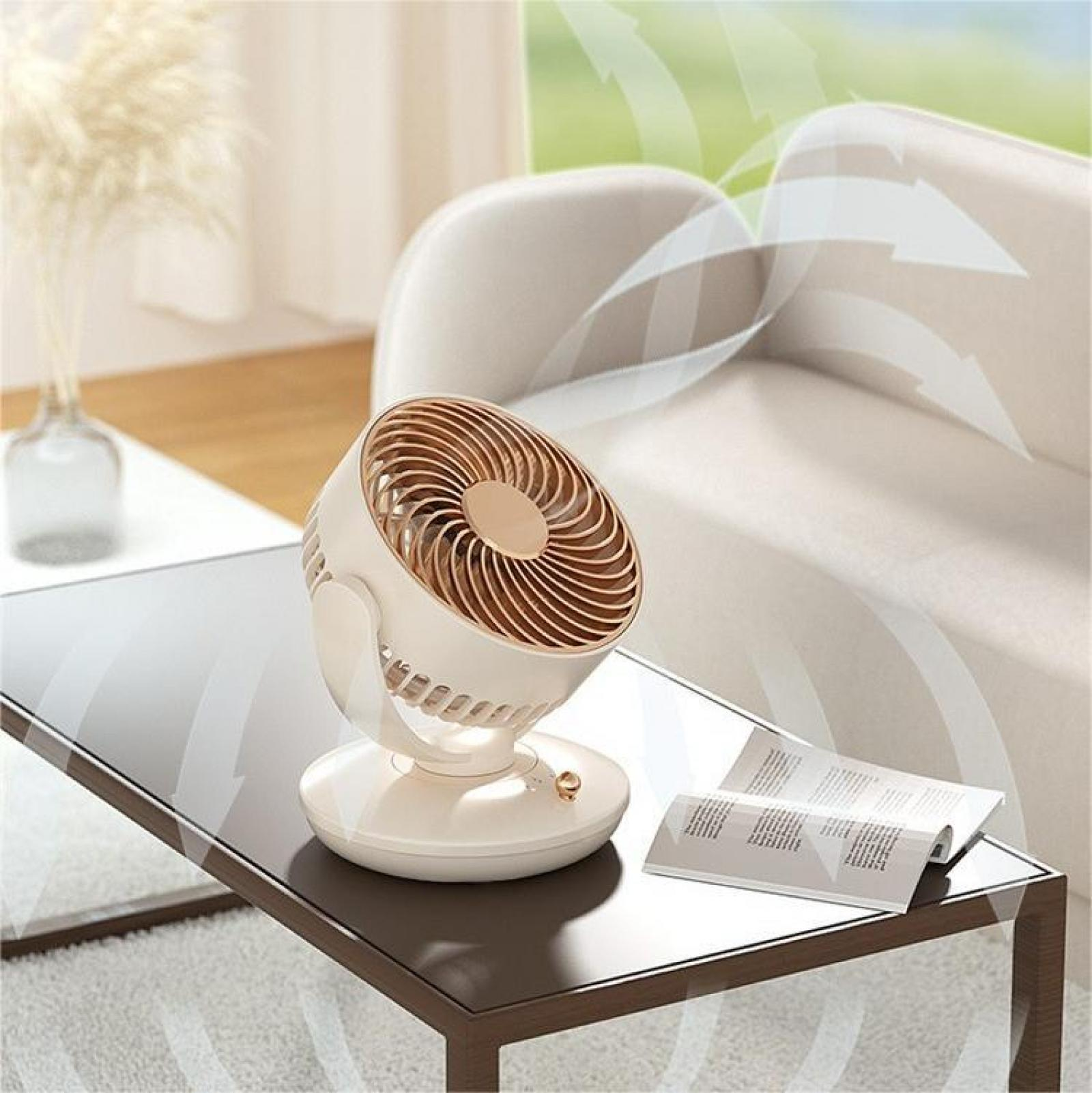 Ein weiß-goldener Ventilator auf einem Glastisch. Pfeile zeigen den Luftstrom an. Im Hintergrund eine Couch und eine Vase.