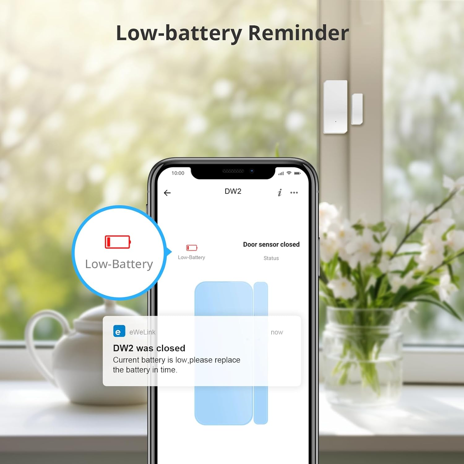 Ein Telefon zeigt eine Warnung vor schwacher Batterie für einen Türsensor an. Im Hintergrund befinden sich eine Teekanne und Blumen in einer Vase.
