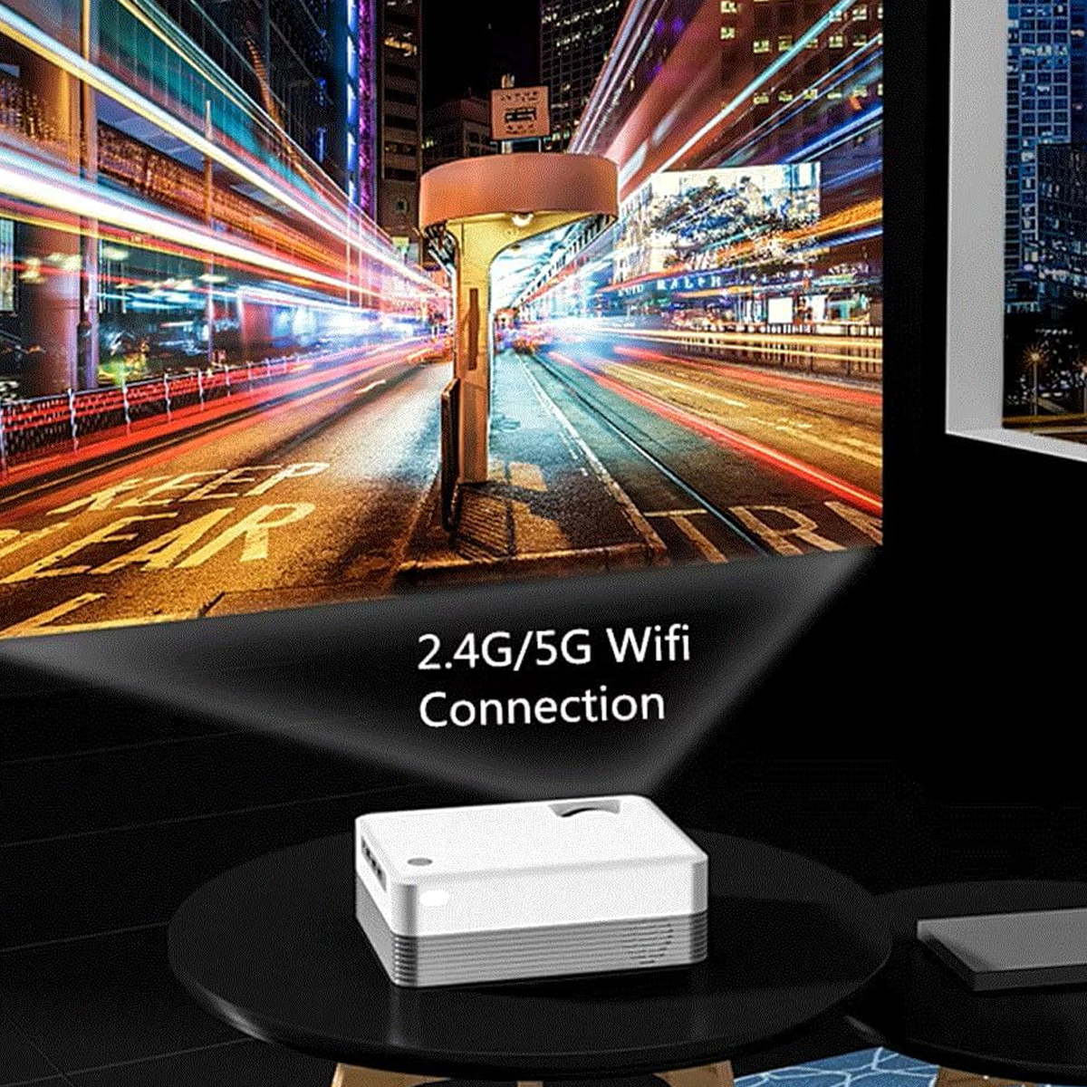 Ein Projektor zeigt eine Stadtlandschaft mit Lichtspuren. Ein weißer Projektor steht auf einem schwarzen Tisch mit der Aufschrift "2.4G/5G Wifi Connection".