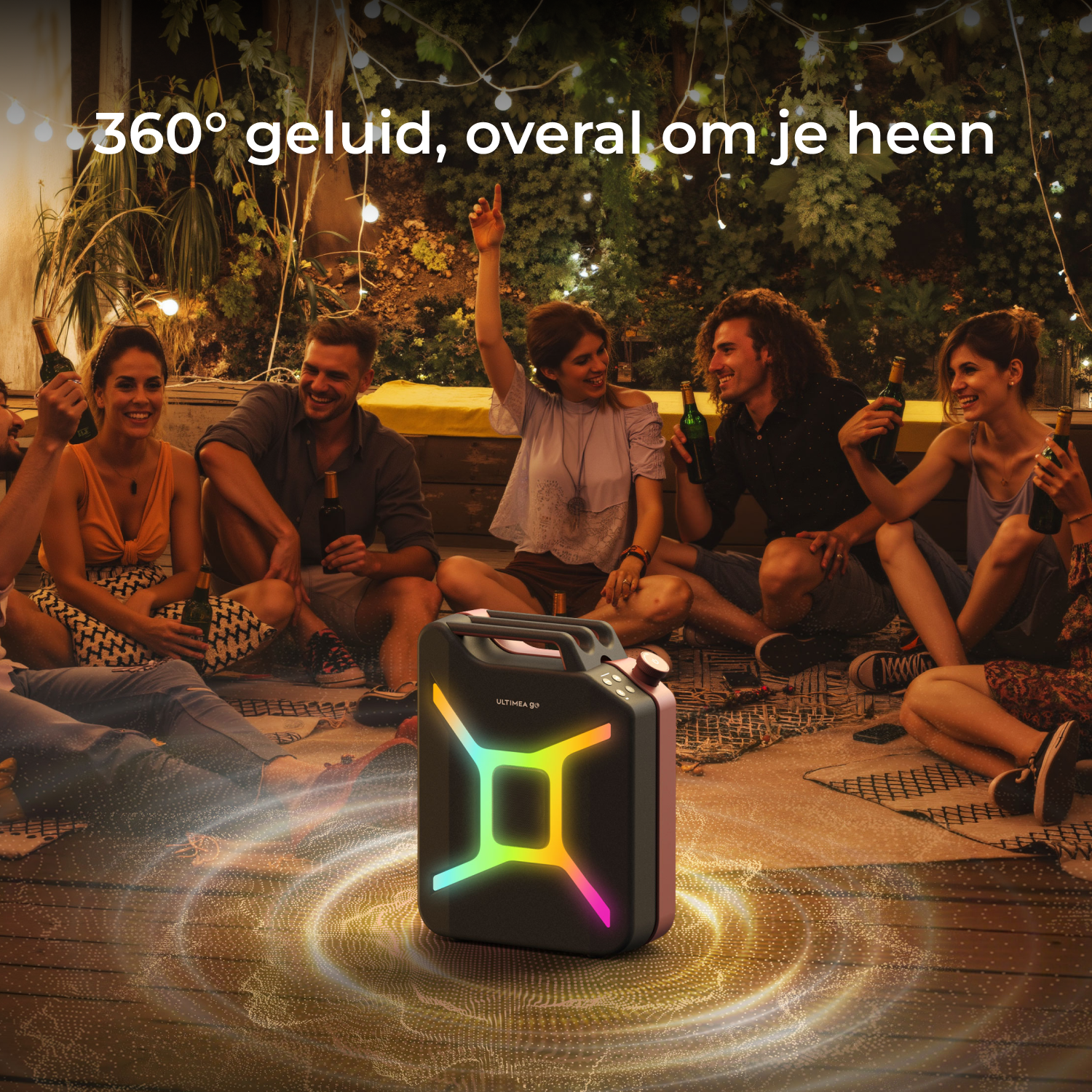 Groep mensen rond een gloeiende luidspreker. Ze zijn 's nachts buiten, met lichtjes en houden flessen vast.