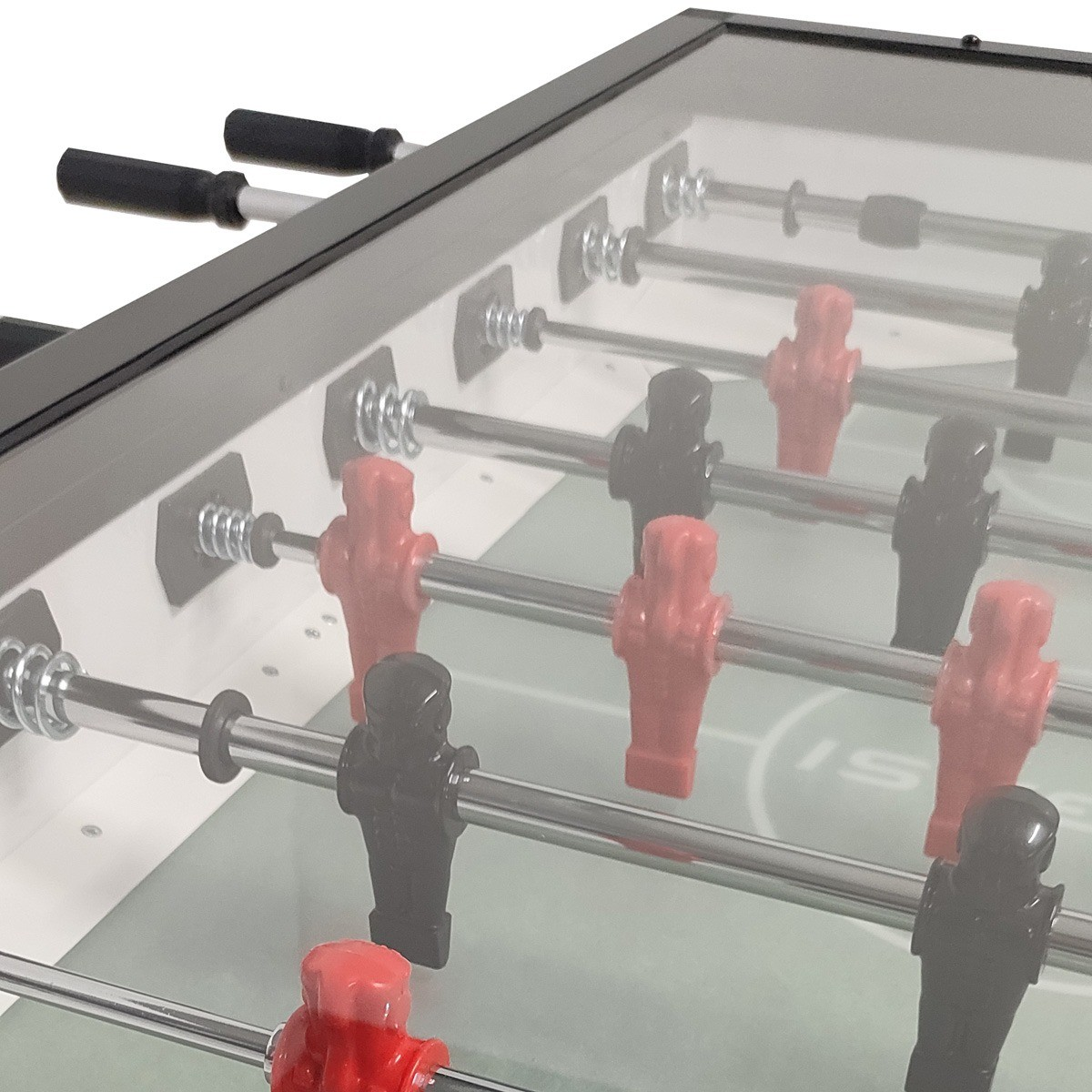 Een tafelvoetbal met rode en zwarte spelers. De tafel heeft een glazen blad. De achtergrond is wazig.
