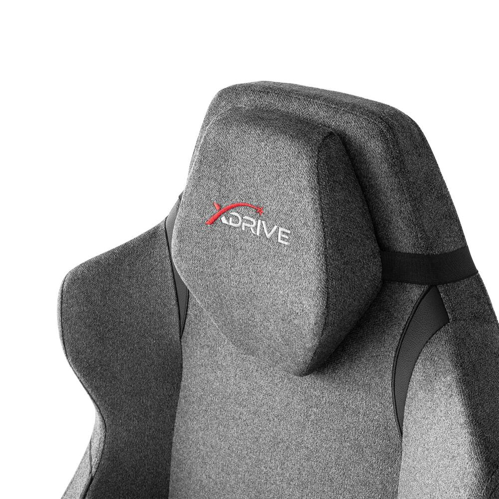 Gri bir oyuncu koltuğunun başlığının yakın çekimi. Kırmızı 'XDRIVE' logosu görünür. Siyah detaylar ve siyah bir kayış da mevcuttur.