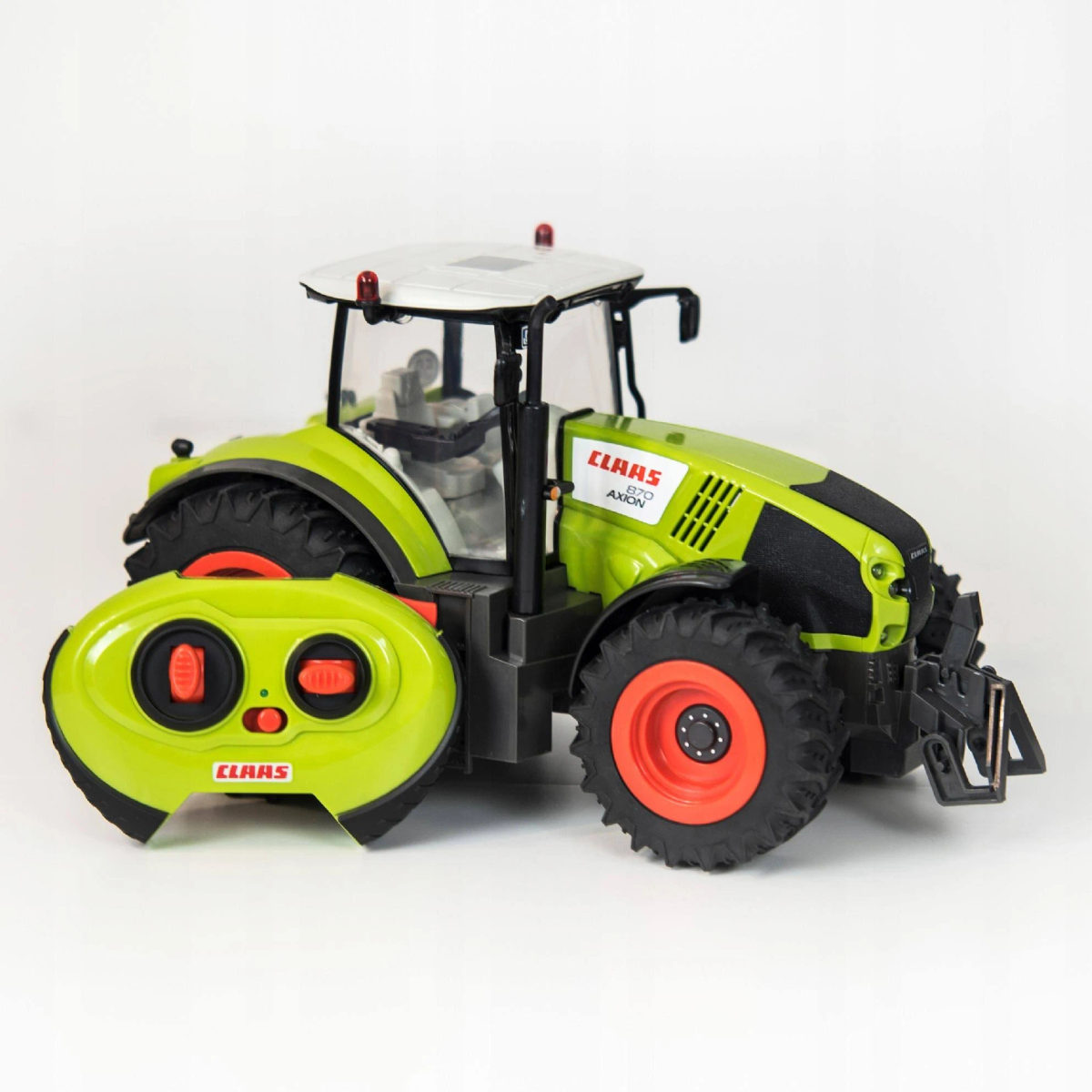 Un tractor de juguete Claas verde con control remoto, neumáticos negros y detalles rojos sobre una superficie blanca.