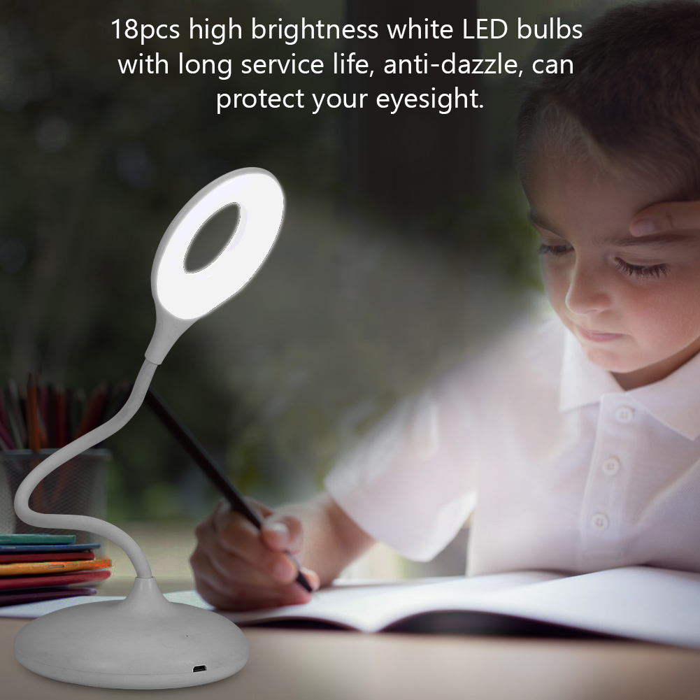 Eine weiße Schreibtischlampe beleuchtet ein Kind beim Schreiben. Die Lampe hat ein ringförmiges Licht. Das Kind trägt ein weißes Hemd.