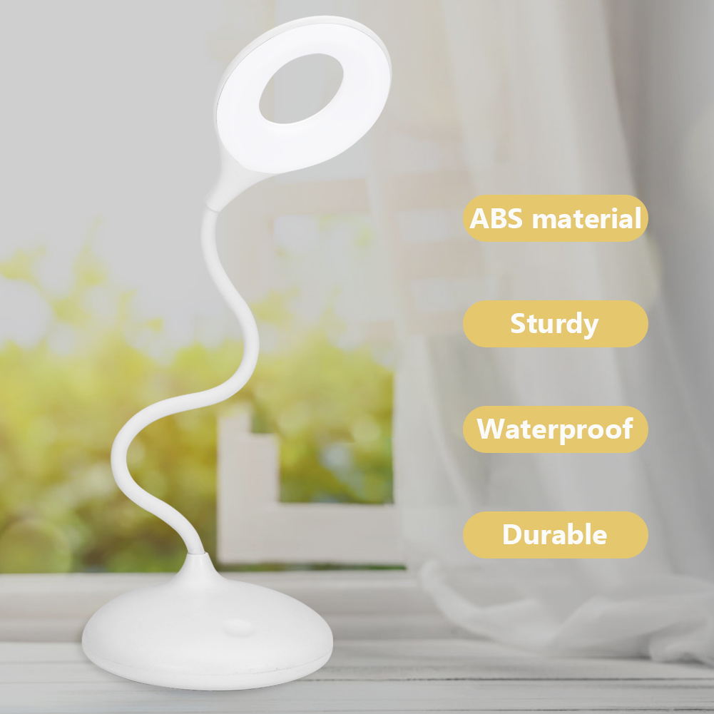 Eine weiße Schreibtischlampe mit kreisförmigem Licht, gebogenem Arm und rundem Sockel. Hintergrund enthält Textlabels und ein Fenster.