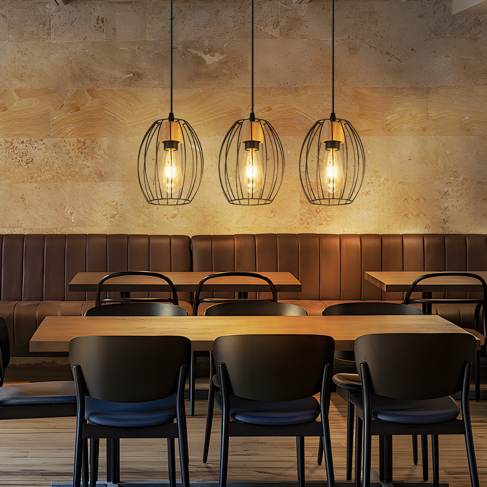 Restaurantinterieur mit drei Pendelleuchten. Tische und Stühle darunter. Braune Leder-Sitzbank und Holzpaneel-Wand.