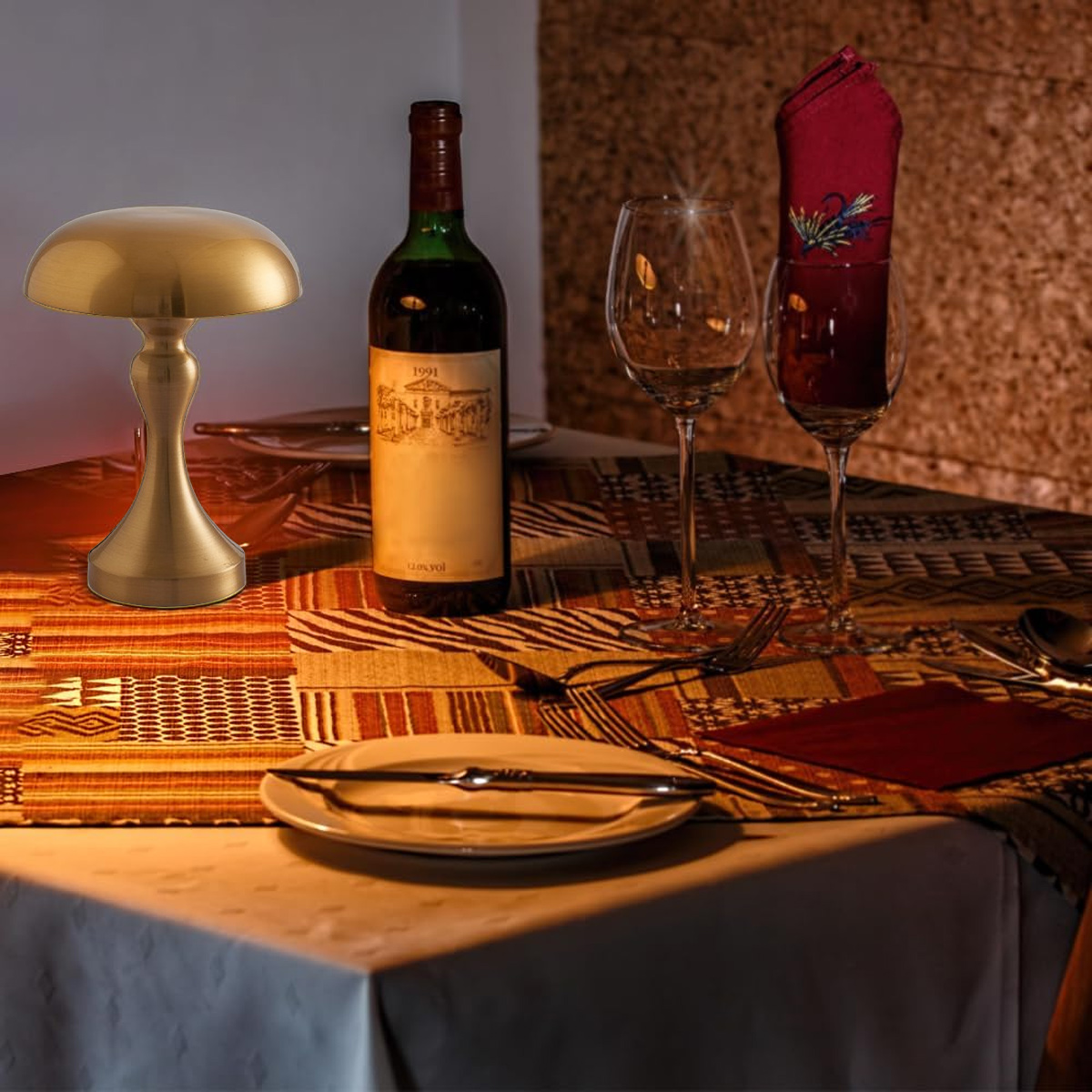 Ein gedeckter Tisch mit Weinflasche, Gläsern und Lampe. Eine gefaltete Serviette und ein Teller sind ebenfalls zu sehen.