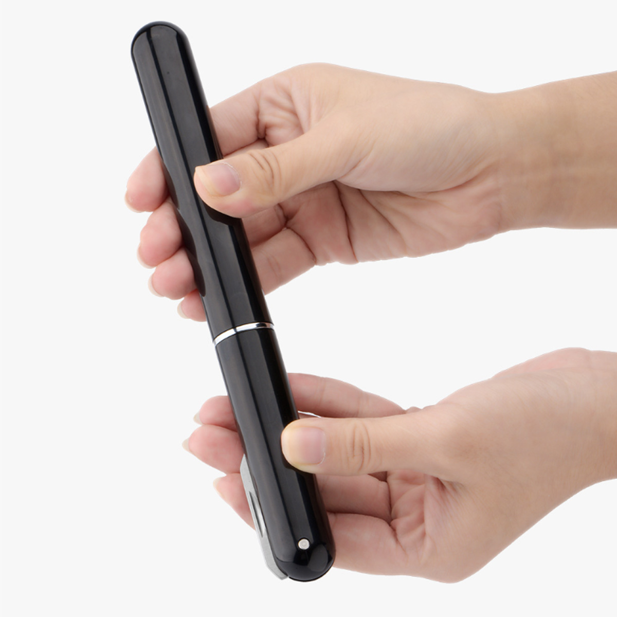 Hände halten einen schwarzen Stift. Der Stift ist zylindrisch mit einem silbernen Band. Der Hintergrund ist weiß.