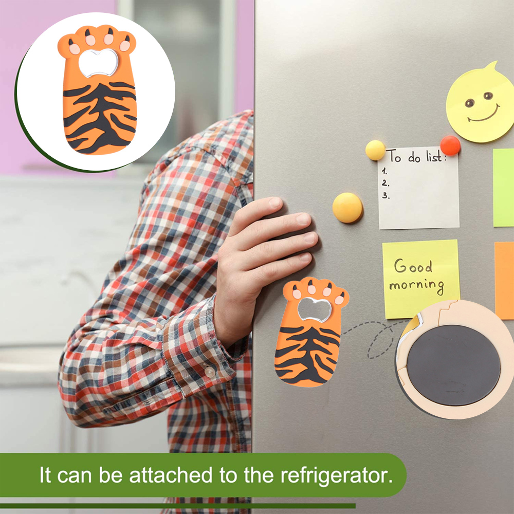 Ein orangefarbener Tigerpfoten-Flaschenöffner an einem Kühlschrank. Die Hand einer Person ist in der Nähe. Notizen und Magnete befinden sich ebenfalls am Kühlschrank.