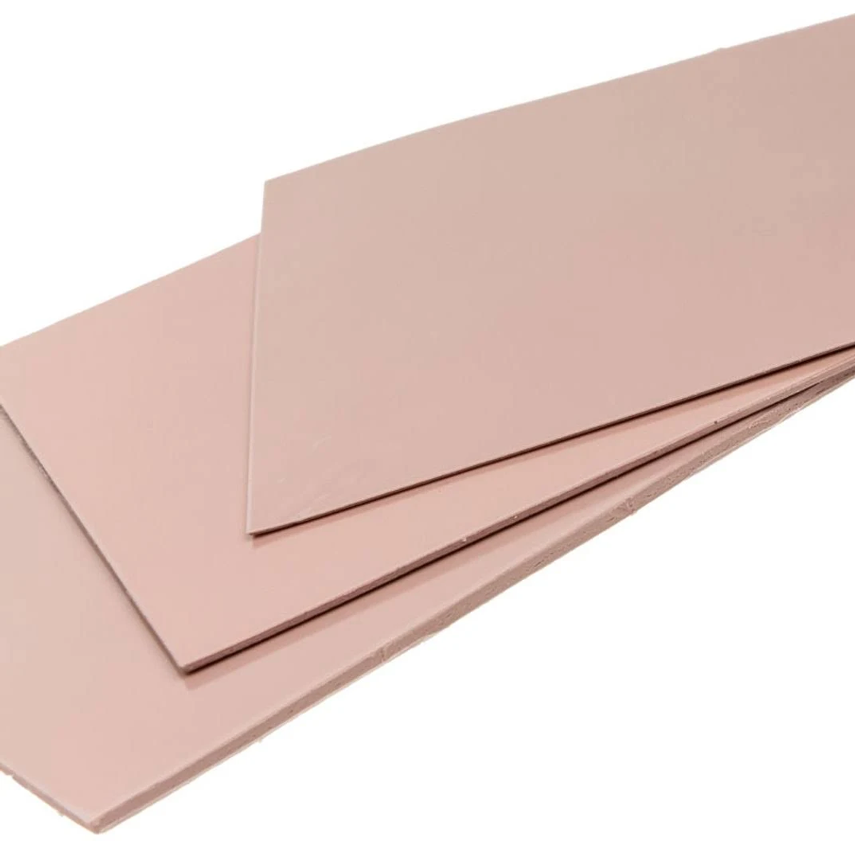 Varias láminas rectangulares rosas apiladas sobre fondo blanco. Las láminas se superponen, mostrando bordes.