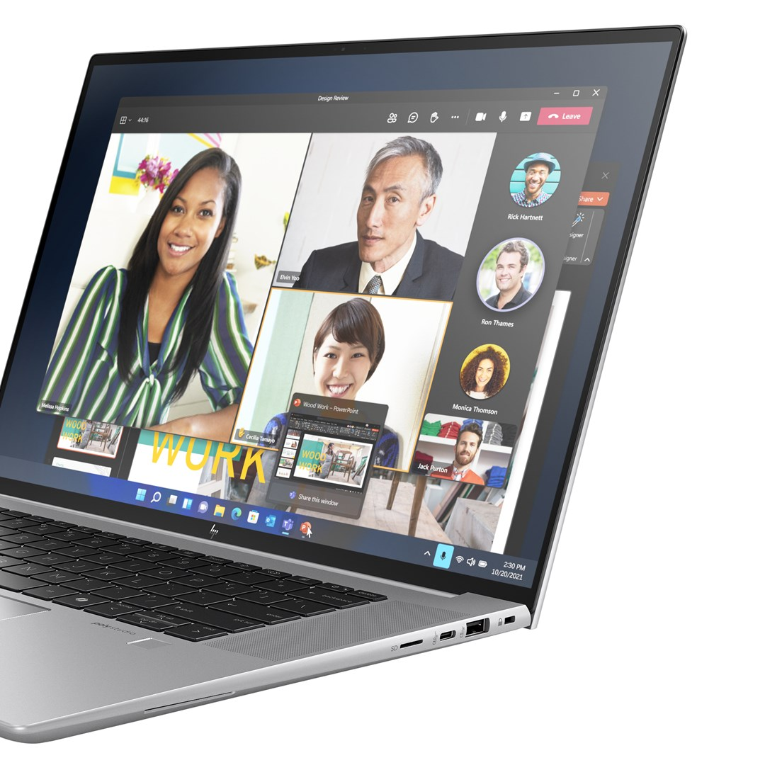 Laptop wyświetlający wideokonferencję z wieloma uczestnikami, w tym kobietą w pasiastą koszulę i prezentację.