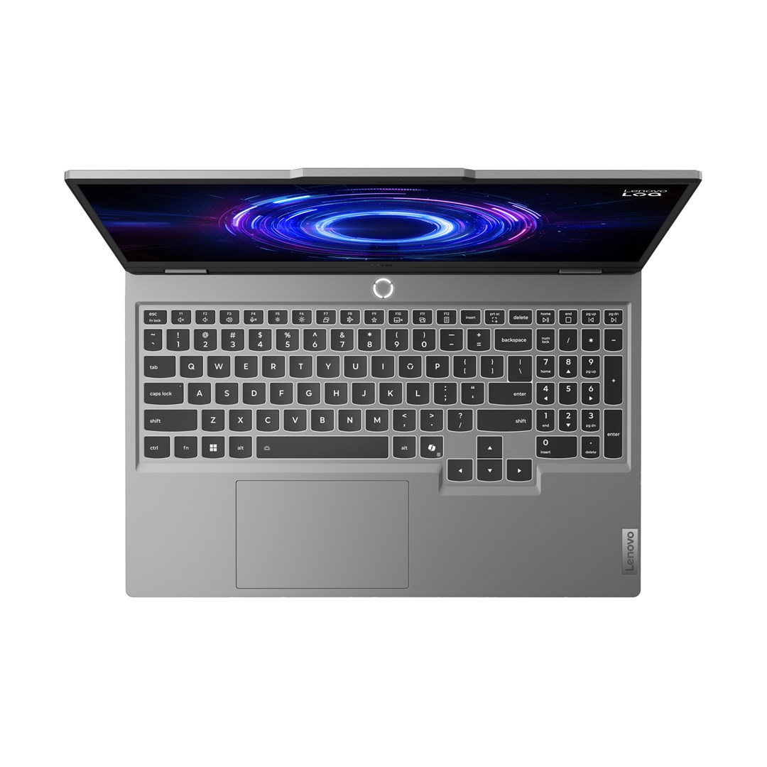 Szary laptop Lenovo jest otwarty, wyświetlając kolorowy ekran. Klawiatura jest widoczna, z logo Lenovo w prawym dolnym rogu.